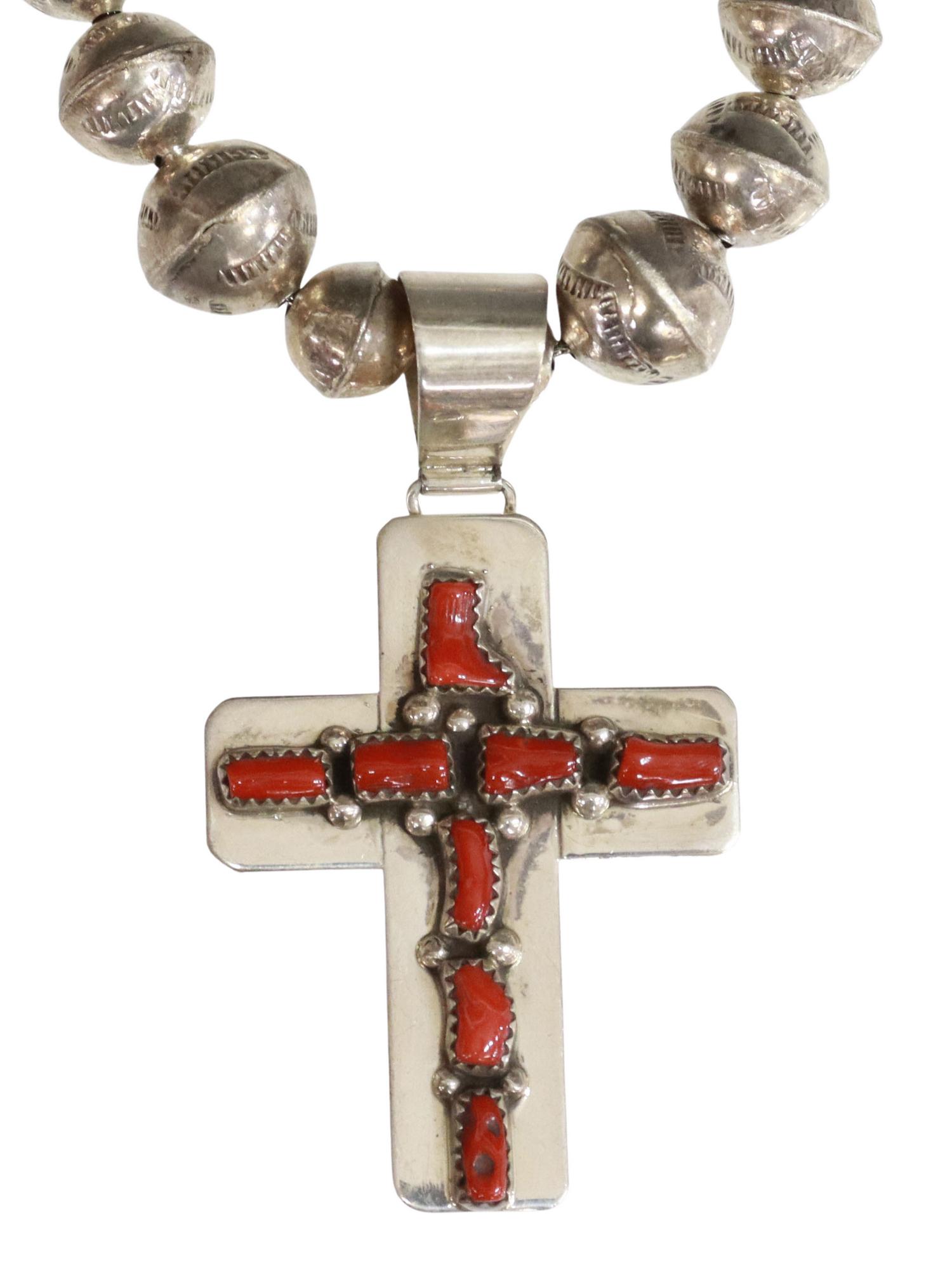 KENNETH JONES NAVAJO STERLING CORAL CROSS PENDANT: Native American sterling silver cross pendant, signed with crossed arrows over J (Kenneth Jones, Navajo/ Dine, 20th c.), cruciform pendant with eight bezel-set red coral pieces, on an assembled, gradu