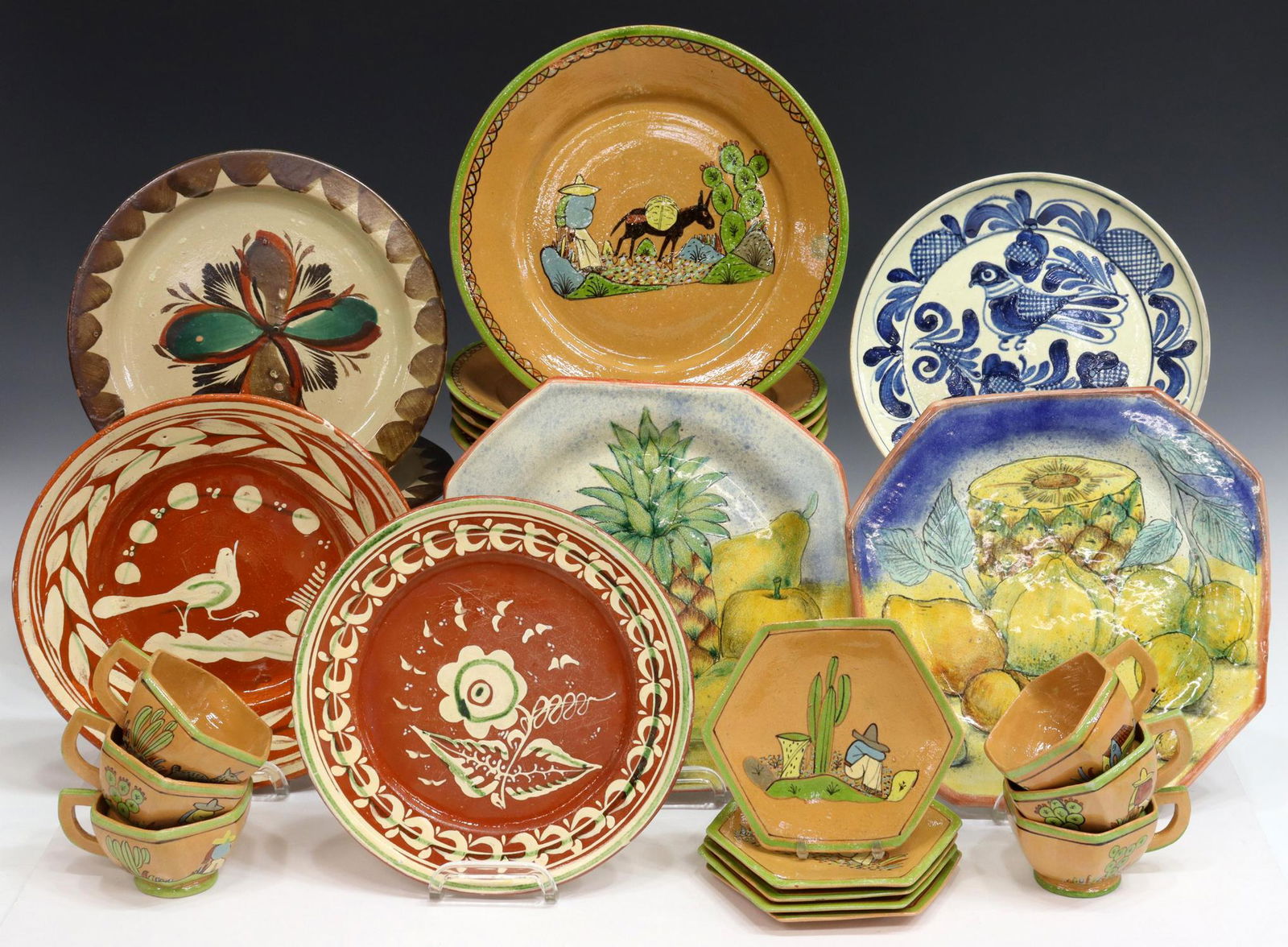 (23) MEXICAN POTTERY GLAZED TABLEWARE, SIESTA MAN: (lot of 23) Mexican polychrome glazed pottery tableware, including: (set of 16) dinnerware, Siesta Man, man taking a siesta by a cactus, consisting of (six) hexagonal teacups, (five) matching saucers,