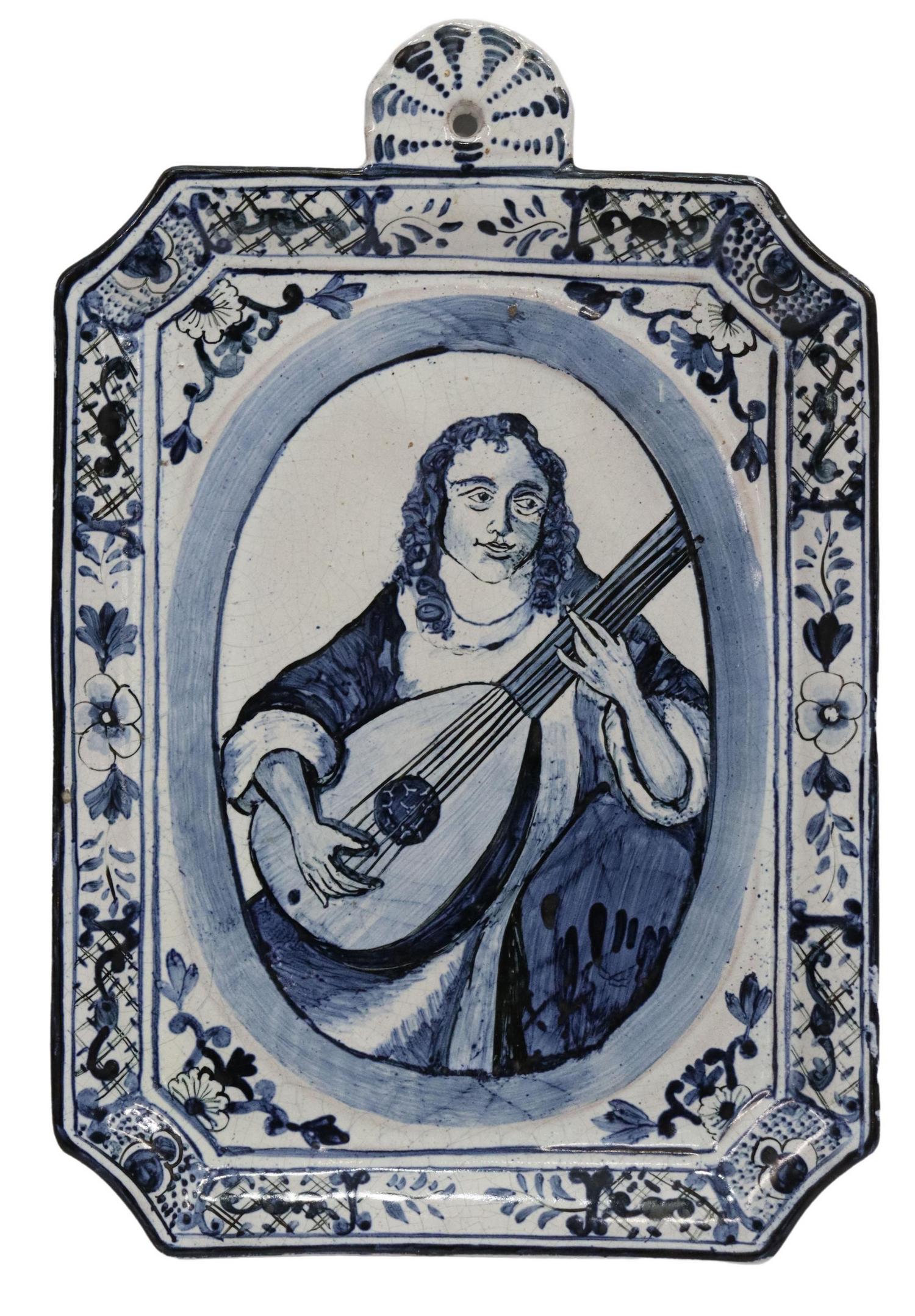 DELFT BLUE & WHITE FIGURAL PLAQUE THE LUTE PLAYER: Delft blue and white tin-glazed earthenware plaque, 18th c., woman playing the lute, approx 11.25"h, 7.5"w, 1.25lbs Start Price: $300.00