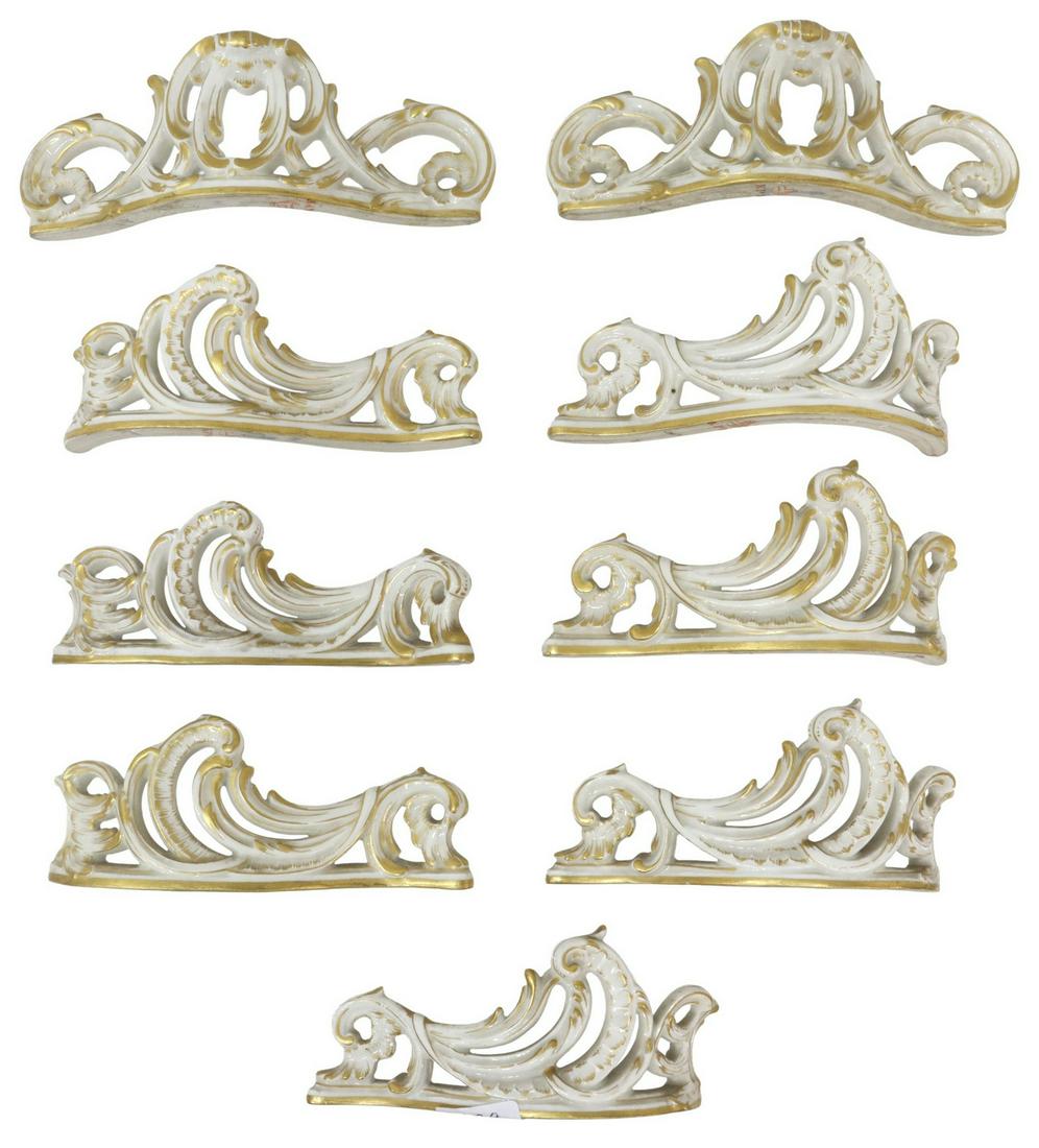 (9) KPM ROCOCO REVIVAL PORCELAIN KNIFE RESTS: (lot of 9) German porcelain knife rests/ table ornaments, K.P.M. (Konigliche Porzellan-Manufaktur), 19th c., parcel gilt, rocaille form, (three) slightly varied designs, red orb mark, largest: approx