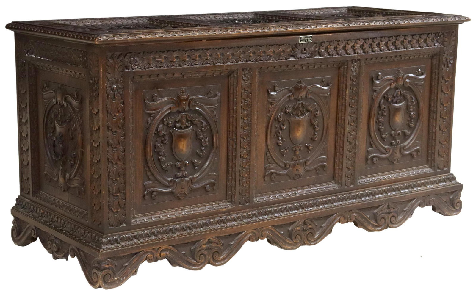 ITALIAN RENAISSANCE REVIVAL CARVED STORAGE TRUNK: Italian Renaissance Revival cassone/ storage trunk, early 20th c., hinged lid, worn paper-lined interior, front panel carved with shields, wrought iron carrying handles, rising on bracket feet, approx
