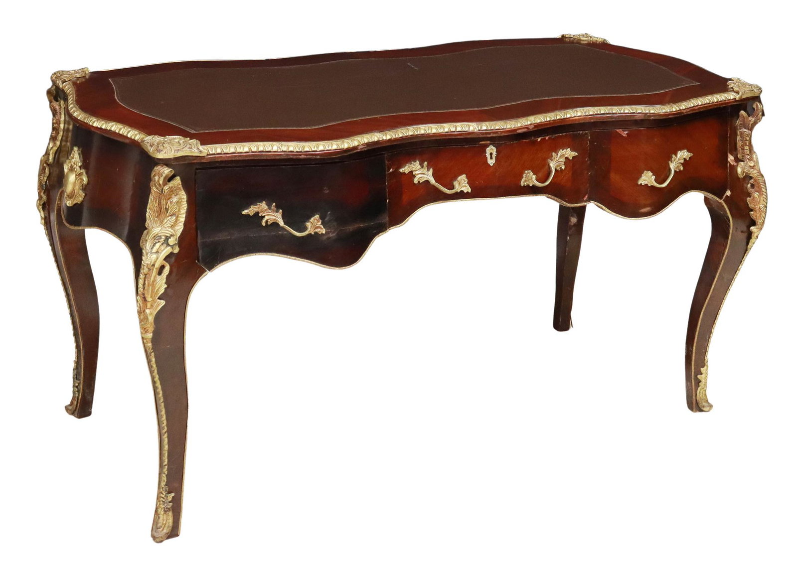 LOUIS XV STYLE MAHOGANY BUREAU PLAT WRITING DESK: Louis XV style bureau plat, late 20th c., accented with brass ormolu, an inset leather writing surface over the serpentine frieze with three drawers, rising on cabriole supports, overall with veneer s