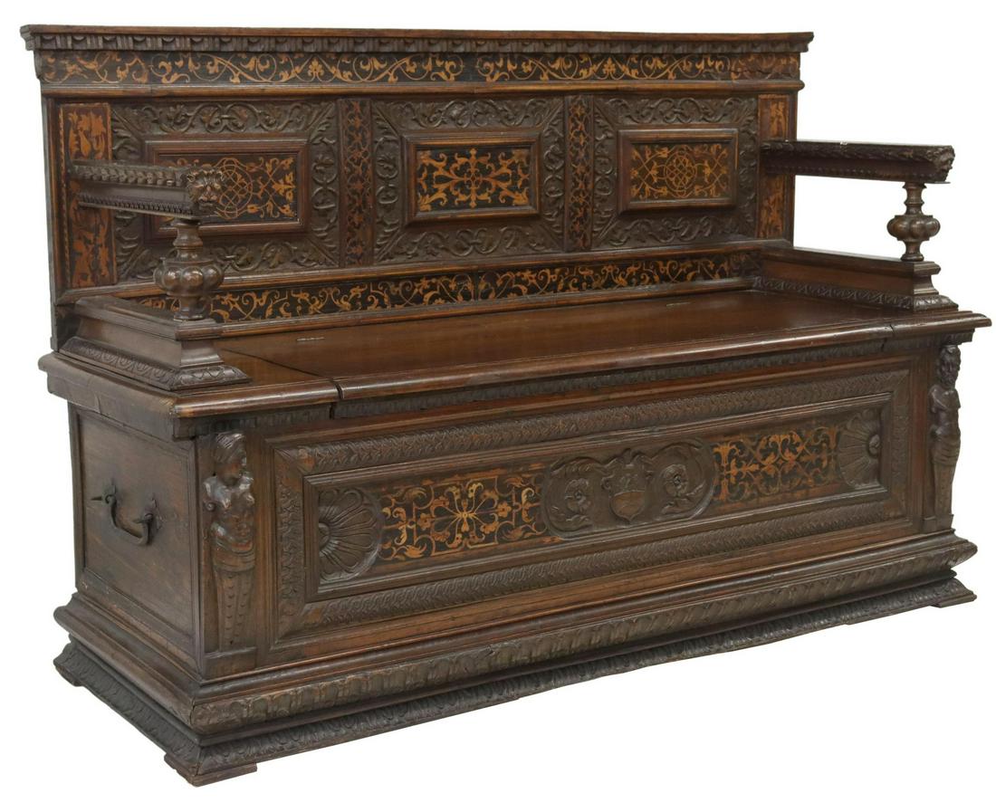 ITALIAN RENAISSANCE REVIVAL WALNUT HALL BENCH: Italian Renaissance Revival carved walnut hall bench, 18th c., with inlaid floral marquetry and carved foliate detailing throughout, lion masks to arms, hinged storage seat above shield crest, flanked