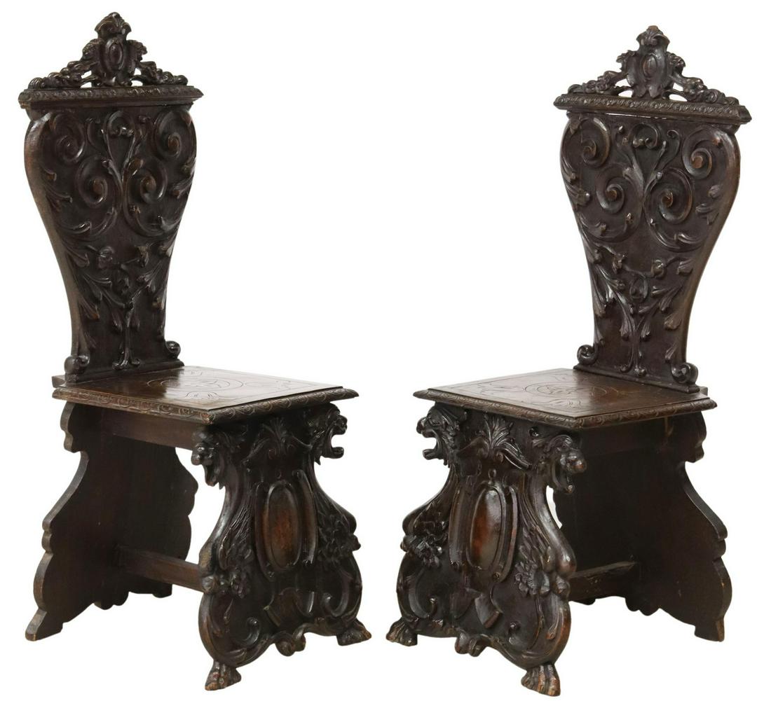 (2) ITALIAN RENAISSANCE REVIVAL WALNUT HALL CHAIRS: (pair) Italian Renaissance Revival carved walnut hall chairs, early 20th c., carved cartouche crest, over foliate vasiform backs, canted seats, rising on shaped griffin supports, ending in paw feet, a