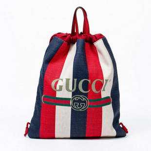 GUCCI 'SYLVIE' STRIPED CANVAS DRAWSTRING BACKPACK: Gucci "Sylvie" drawstring backpack, in striped red, white and blue canvas, with red leather trim, dual flat handles, drawstring closure at top, opening to red canvas lined interior, containing single