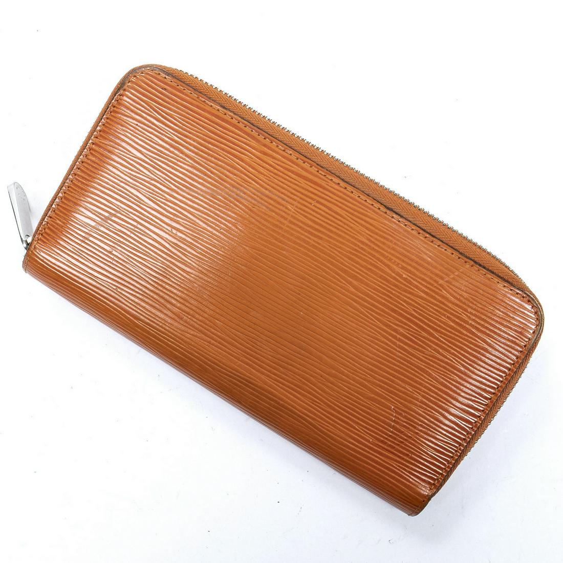 LOUIS VUITTON "ZIPPY" ORANGE EPI LEATHER WALLET: Louis Vuitton "Zippy" wallet, in orange Epi leather, with silver-tone hardware, wrap-around zip closure opening to orange interior, with eight card slots, dual bill compartments and five additional co