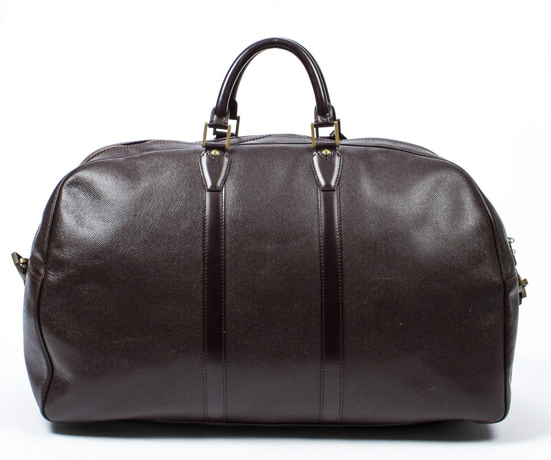 LOUIS VUITTON 'KENDALL" BURGUNDY TAIGA TRAVEL BAG: Louis Vuitton "Kendall GM", in burgundy taiga leather, with brass-tone hardware, dual rolled handles, single adjustable shoulder strap, luggage tap, zip closure at top, some creasing, spotting, scuffi