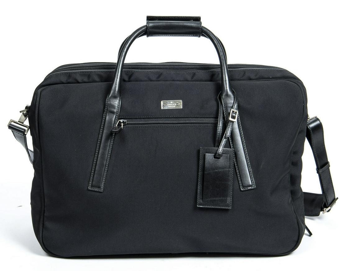 GUCCI BLACK CANVAS WEEKENDER TRAVEL BAG: Gucci weekender travel bag, having black canvas exterior, with silver-tone hardware, black leather trim, dual rolled top handles, optional flat shoulder strap, single exterior zip pocket at front face