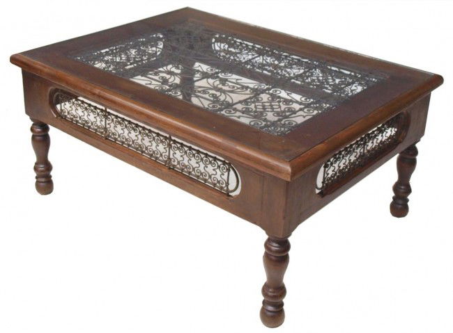 LARGE MOROCCAN WOOD & METAL GLASS TOP COFFEE TABLE: Large Moroccan wood coffee table, the top and skirt set with scrolled metal, rising on four turned legs, accompanied by a glass top, 20.5"h, 40.5"w, 33.5"d Start Price: $100.00