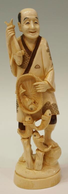 JAPANESE CARVED IVORY OKIMONO, A FISHERMAN: **This lot will not be shipped Internationally**Japanese figural carved ivory okimono, a fisherman emptying his abundantly filled basket of fish, stained accents, characters underfoot as pictured, 10"