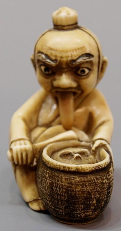 JAPANESE IVORY NETSUKE, ARTICULATED MAN: **This item will not be shipped Internationally** Japanese carved ivory netsuke formed as a man seated before a cooking pot that holds a human skull, the man has an articulated head and his tongue mov