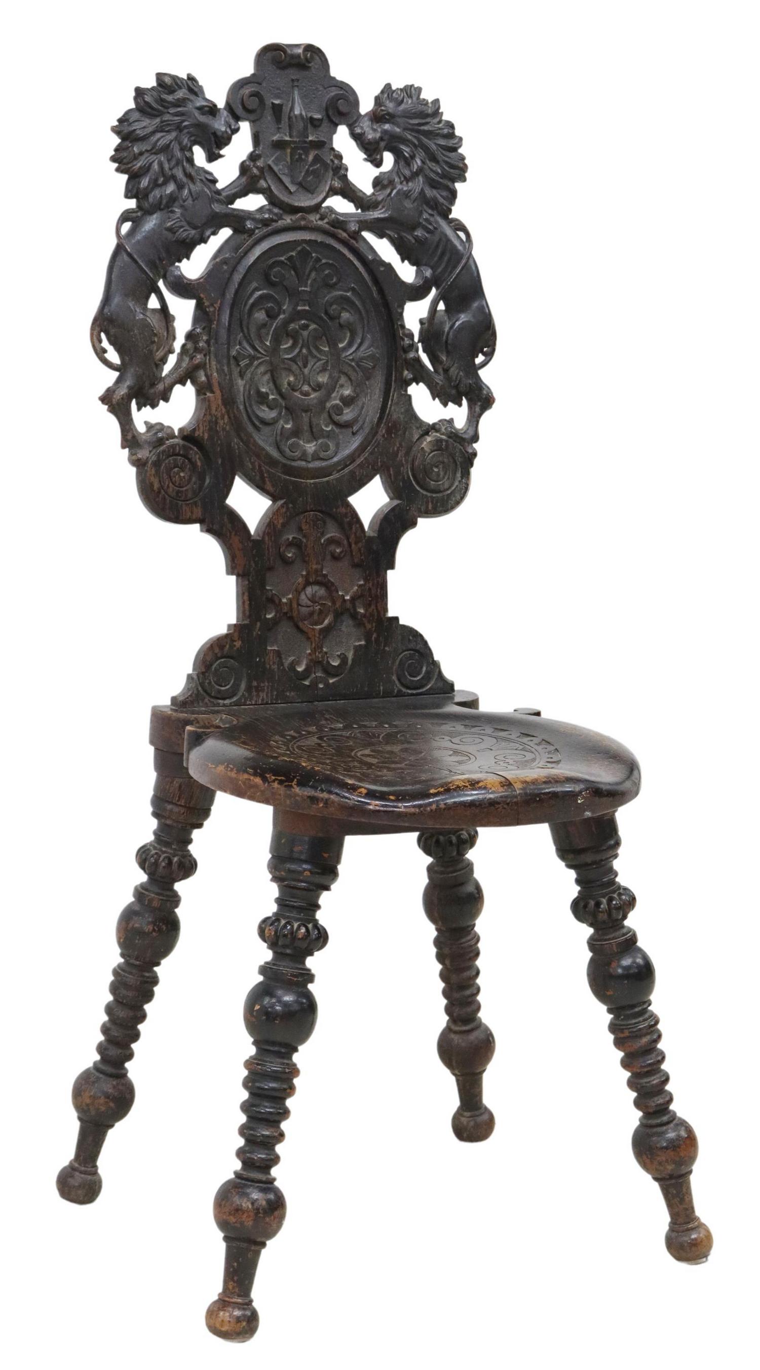 RENAISSANCE REVIVAL CARVED LION HALL CHAIR: Renaissance Revival carved hall chair, early 19th c., cartouche crest with wine bottle and playing cards, flanked by lions rampant, over floral carved seat, rising on turned legs, ending in bun feet, 