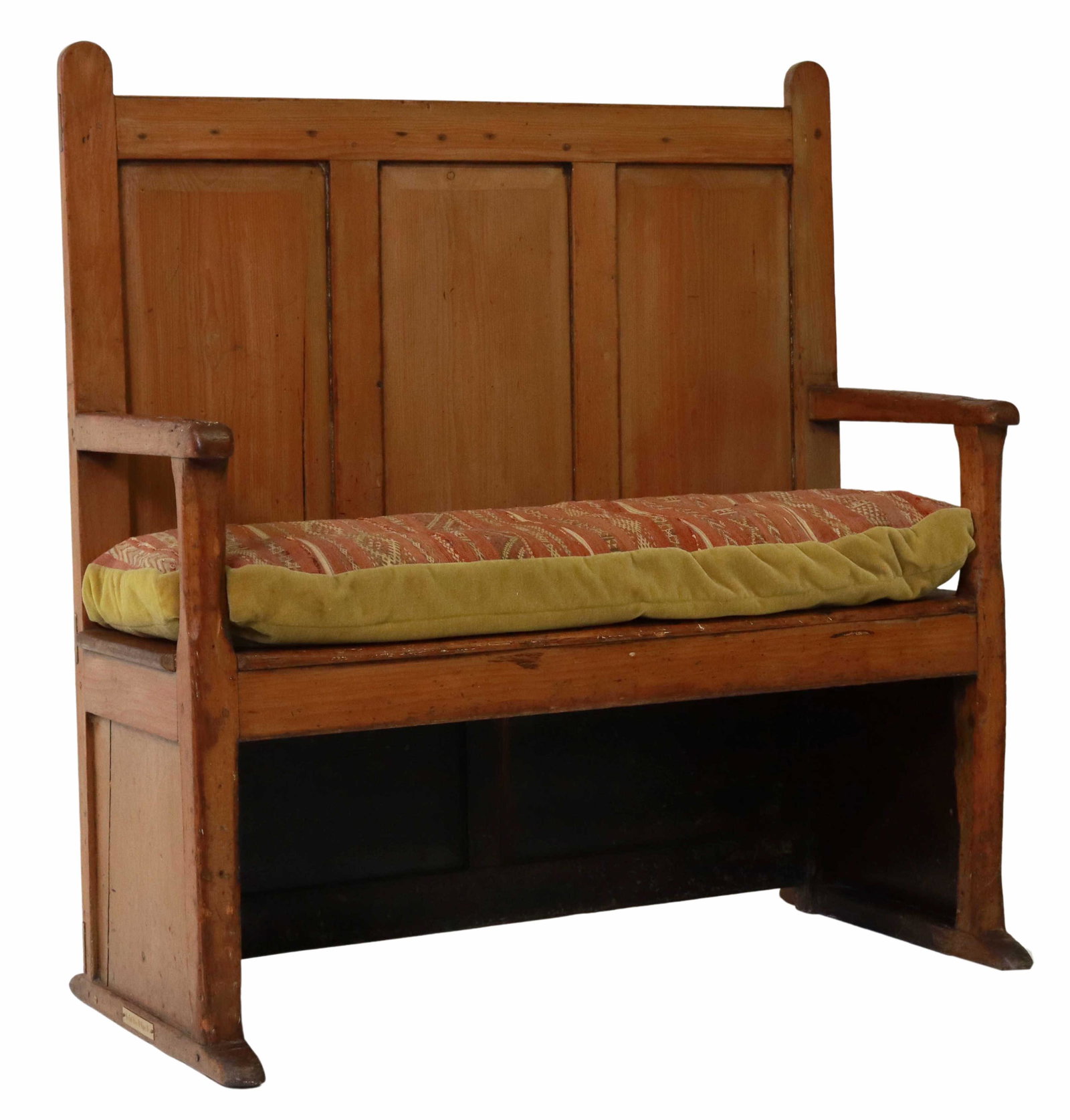 PRIMITIVE ENGLISH PINE SETTLE/ BENCH: Primitive English pine settle/ bench, 18th/ 19th c., displaying through mortise and tenon joinery, paneled back, open armrests, later flat weave and mohair seat cushion, rising on a molded shoe base, 