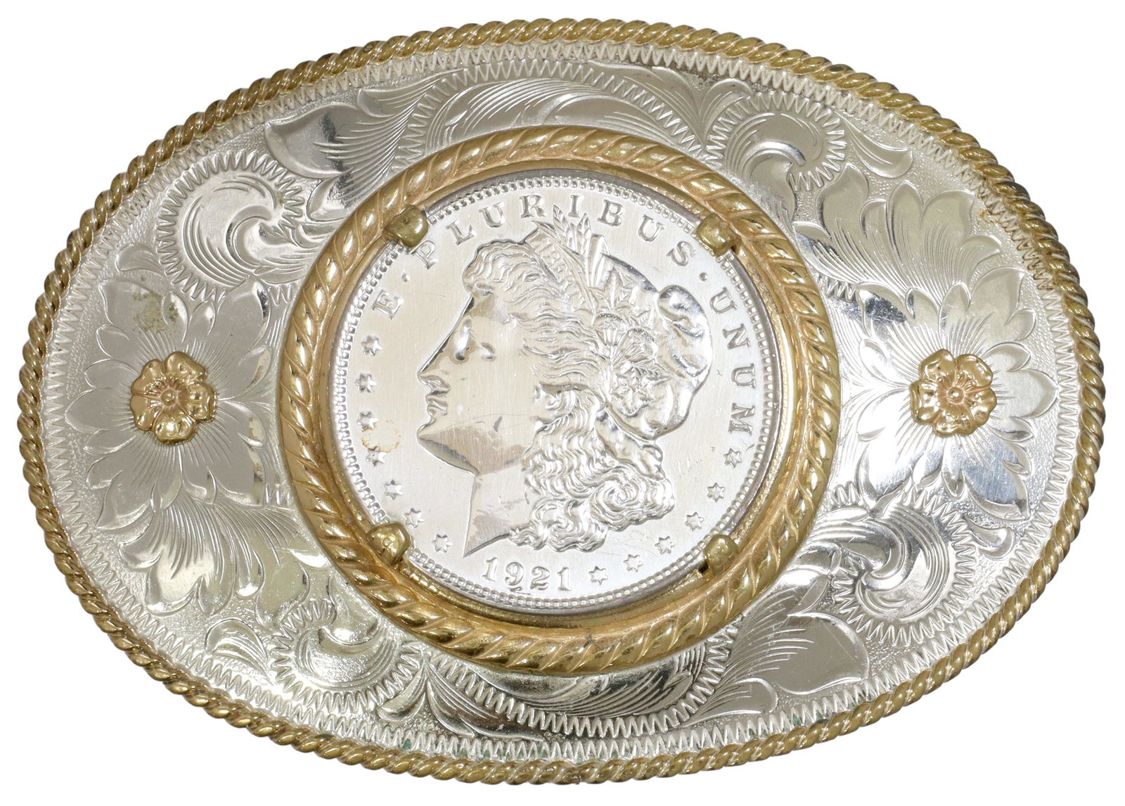 MONTANA SILVERSMITHS MORGAN SILVER DOLLAR BUCKLE: Western style German silver belt buckle, Montana Silversmiths, Columbus, Montana, foliate engraved plaque of oval form, with gilt accents, central 1921 Morgan silver dollar, overall: approx 2.5"h, 3.2