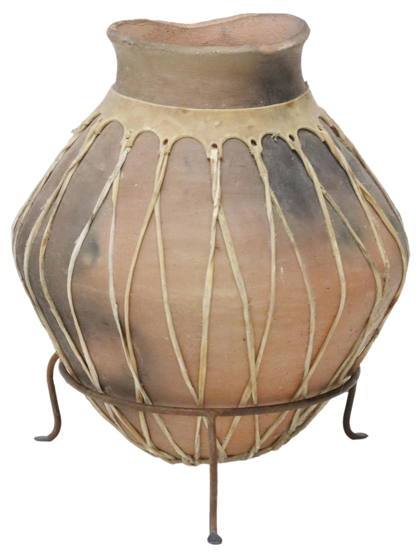 TARAHUMARA TERRACOTTA OLLA VESSEL, MEXICO: Terracotta olla vessel, Tarahumara people, Mexico, with rawhide lacing to exterior, on later footed iron stand, typical losses to rim, overall: approx 15"h, jar: approx 14.75"h, 13"diam, 14.5lbs total