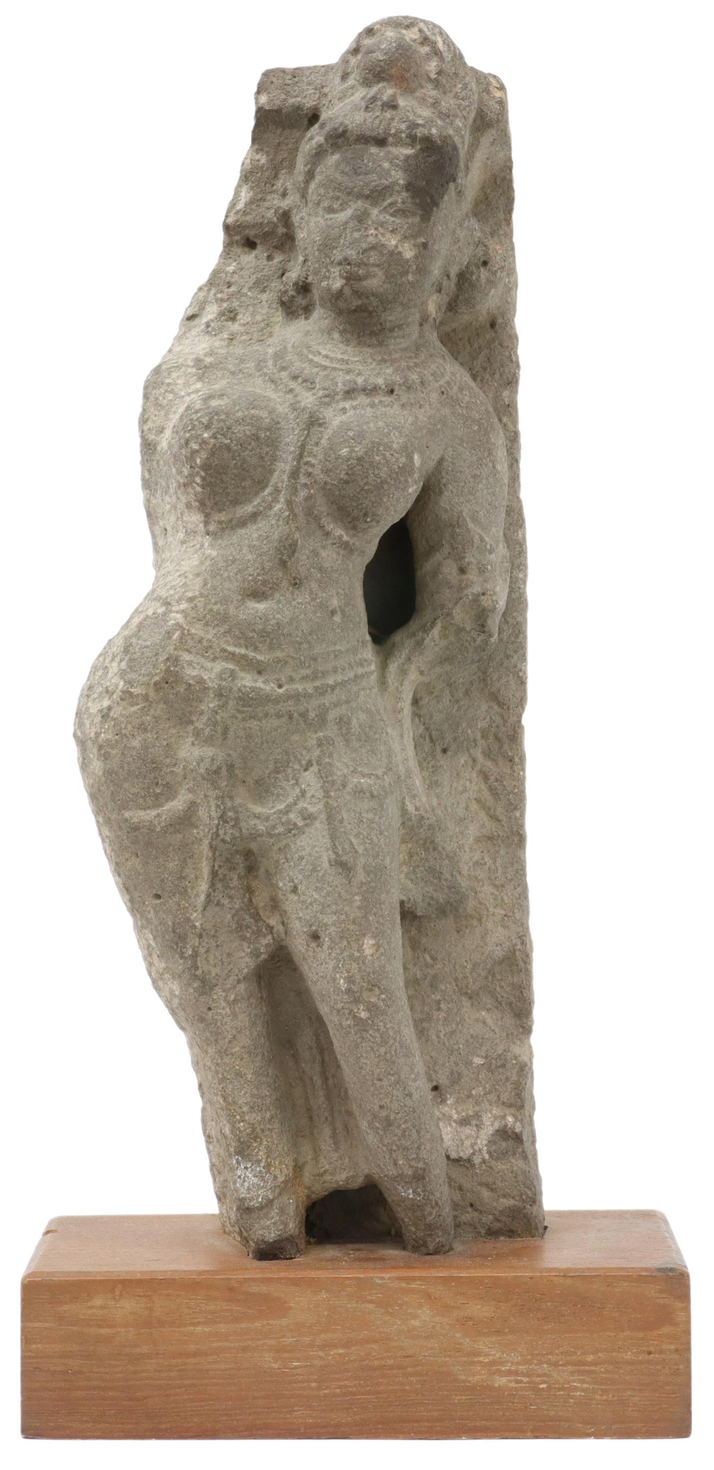 CARVED STONE BUDDHIST YAKSHI FIGURE, INDIA: Carved stone Buddhist Yakshi figure, India, female figure in contrapposto pose, adorned in beads, rising on wood base, approx 15.5"h, 7"w, 4"d, 14lbs **Provenance: From the collection of Mrs. Bettye W