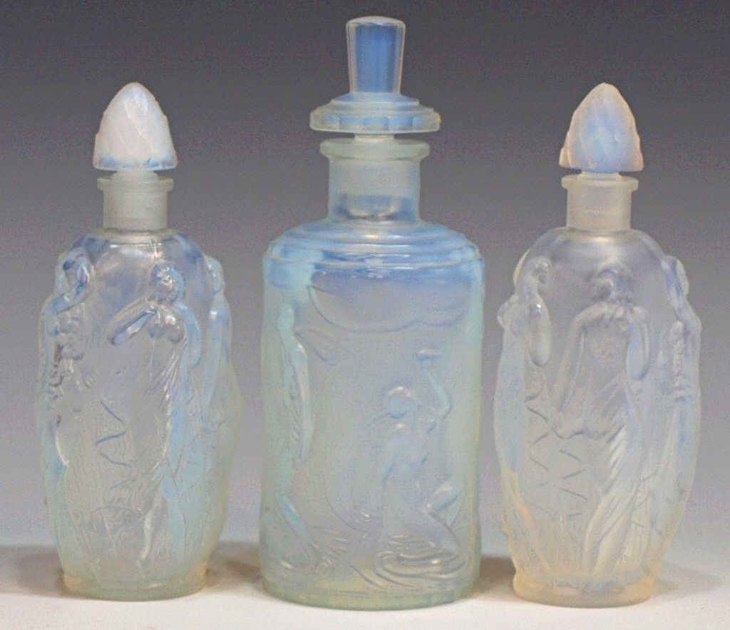 LOT SABINO PARIS ART GLASS OPALESCENT PERFUMES: (lot of 3) Sabino opalescent art glass scent bottles: (2) miniature bottles surrounded by semi-nude female figures in relief, each with 'Sabino Paris' mark, 3.75"h; (1) 'Frivolites' scent bottle, reta