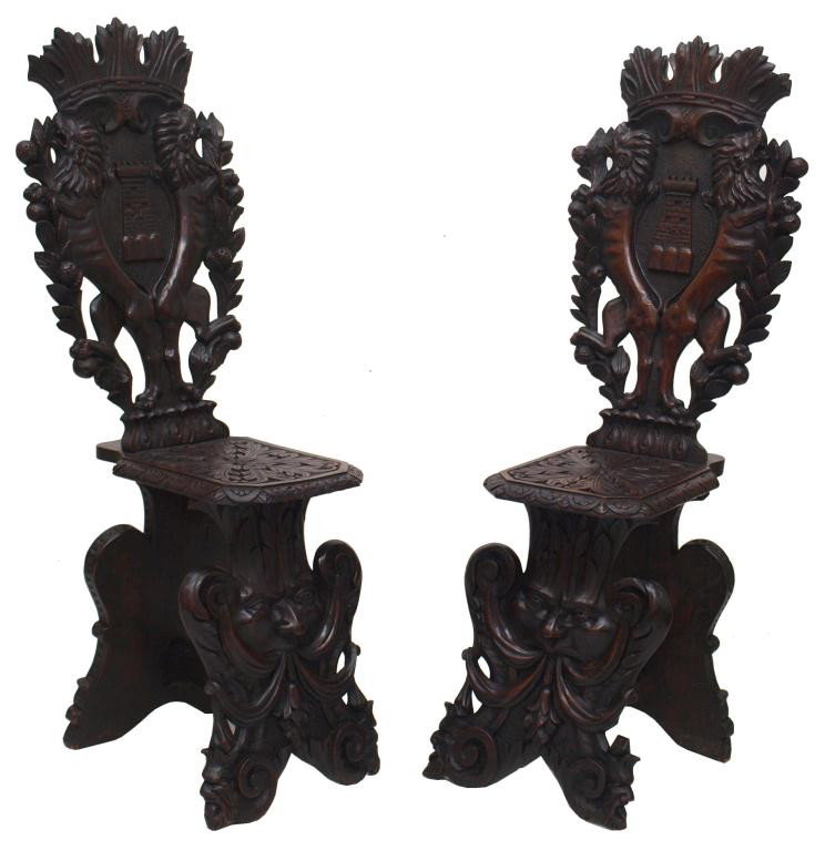 ITALIAN RENAISSANCE STYLE CARVED HALL CHAIRS: (pair) Highly carved Italian Renaissance style hall chairs, late 19th/ early 20th c., a foliated crown crest surmounting the high back of each carved with opposed lions, foliates and castle, floral ca