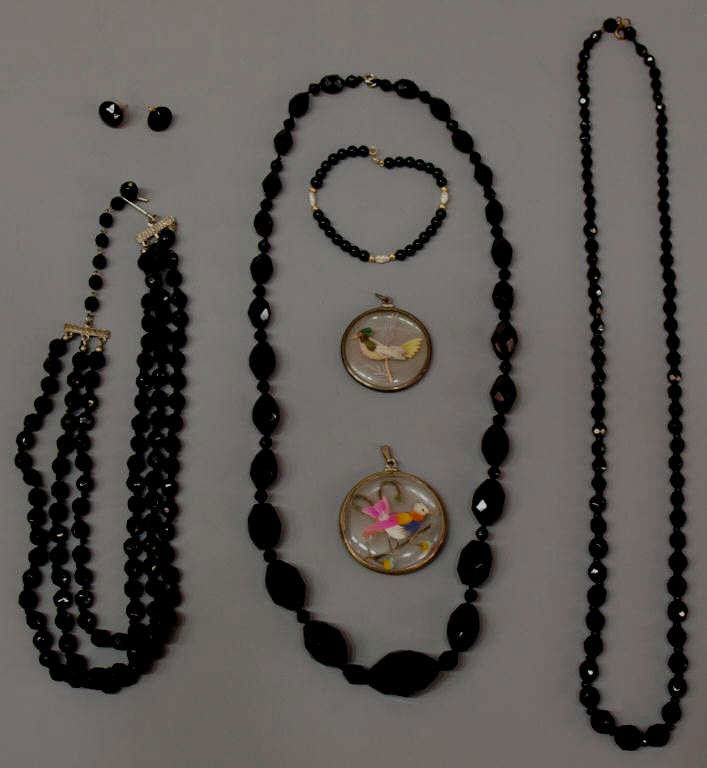 ANTIQUE/VINTAGE JET BEAD & FEATHER BIRD PENDANTS: (lot of 8) Vintage jewelry group comprising (3) faceted jet bead necklaces, one three stands, a similar (pair) of earrings, (1) black beaded bracelet with pearl and gold spacers, (2) antique 'feather'