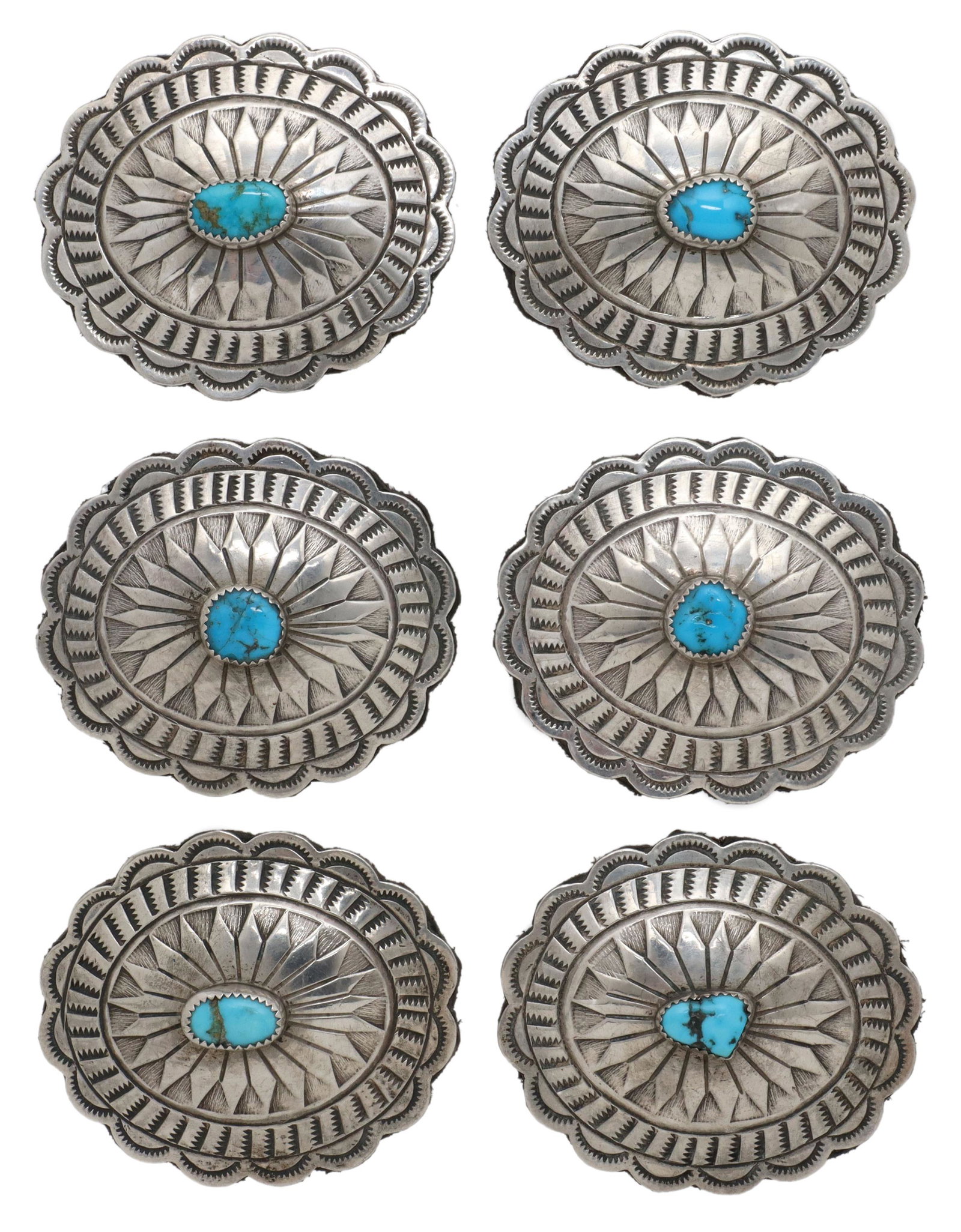 (6) NATIVE AMERICAN SILVER & TURQUOISE CONCHOS: (lot of 6) Native American silver (content unknown) conchos, oval form with scalloped edge, stamped designs, central bezel-set turquoise cabochon, leather backing, approx 2"h, 2.5"w, 174.5 grams total