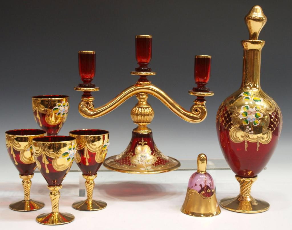(7) MURANO RUBY & GOLD DECANTER SET, CANDELABRA: (lot of 7) Heavily gilded Murano ruby glassware, each piece with enamel floral decoration: (5) drinks set with 14"h decanter with loss of gilt to base, four wine glasses, 5.25"h; (1) three light cande
