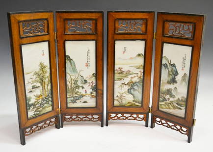 CHINESE FOUR PANEL PORCELAIN TABLE SCREEN: Chinese painted porcelain table screen, 20th c., four artist signed panels with painted landscape scenes, carved wood accents above and below, missing hinges, one with carved accent damage, porcelain