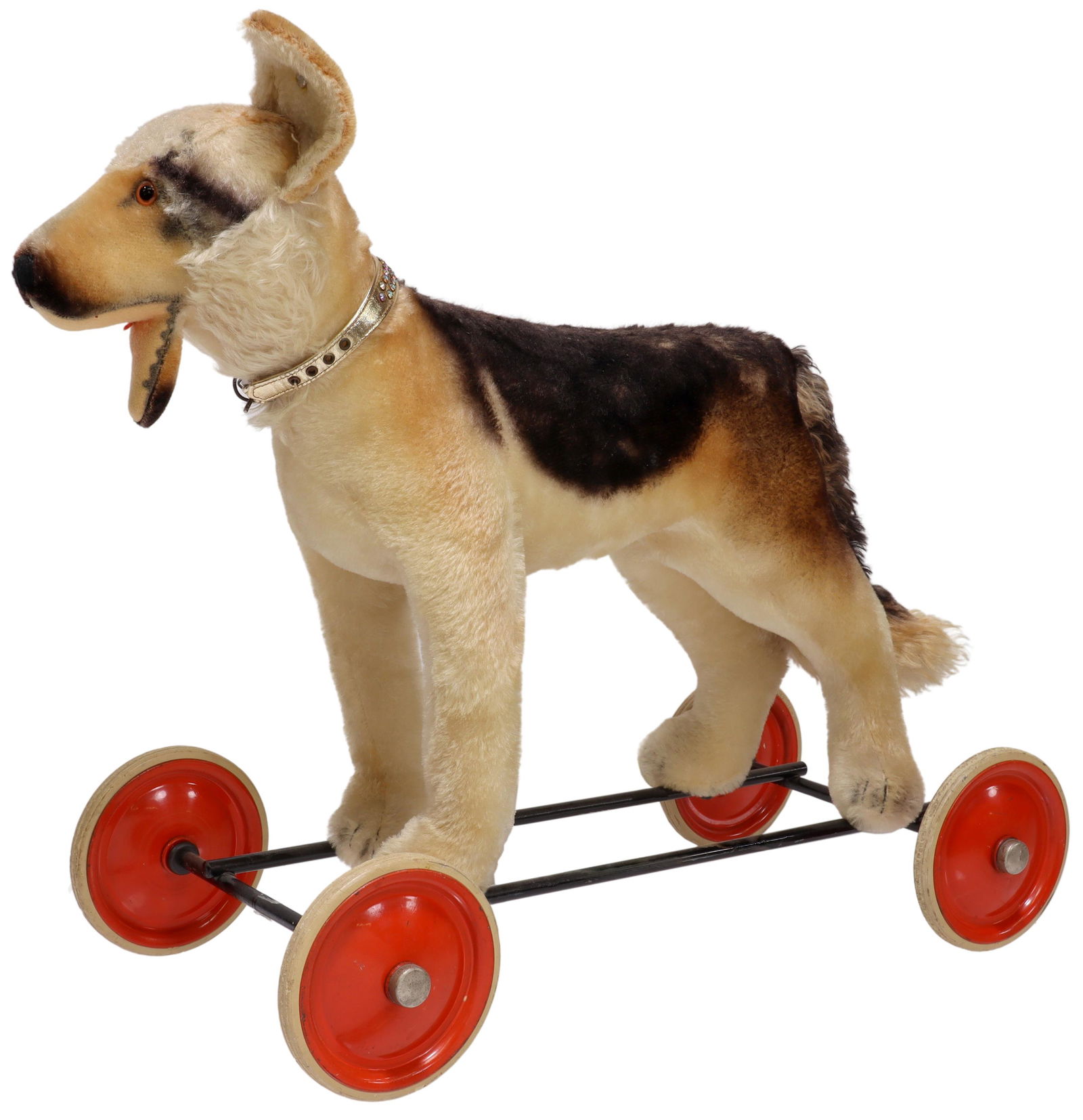 STEIFF SHEPHERD DOG RIDE ON PULL TOY ON WHEELS: Steiff mohair German Shepherd dog, mid 20th c., with set eyes, attached to metal frame with four wheels, lacking one ear, the other ear loosely attached retaining Steiff button, pull "growler" mechani