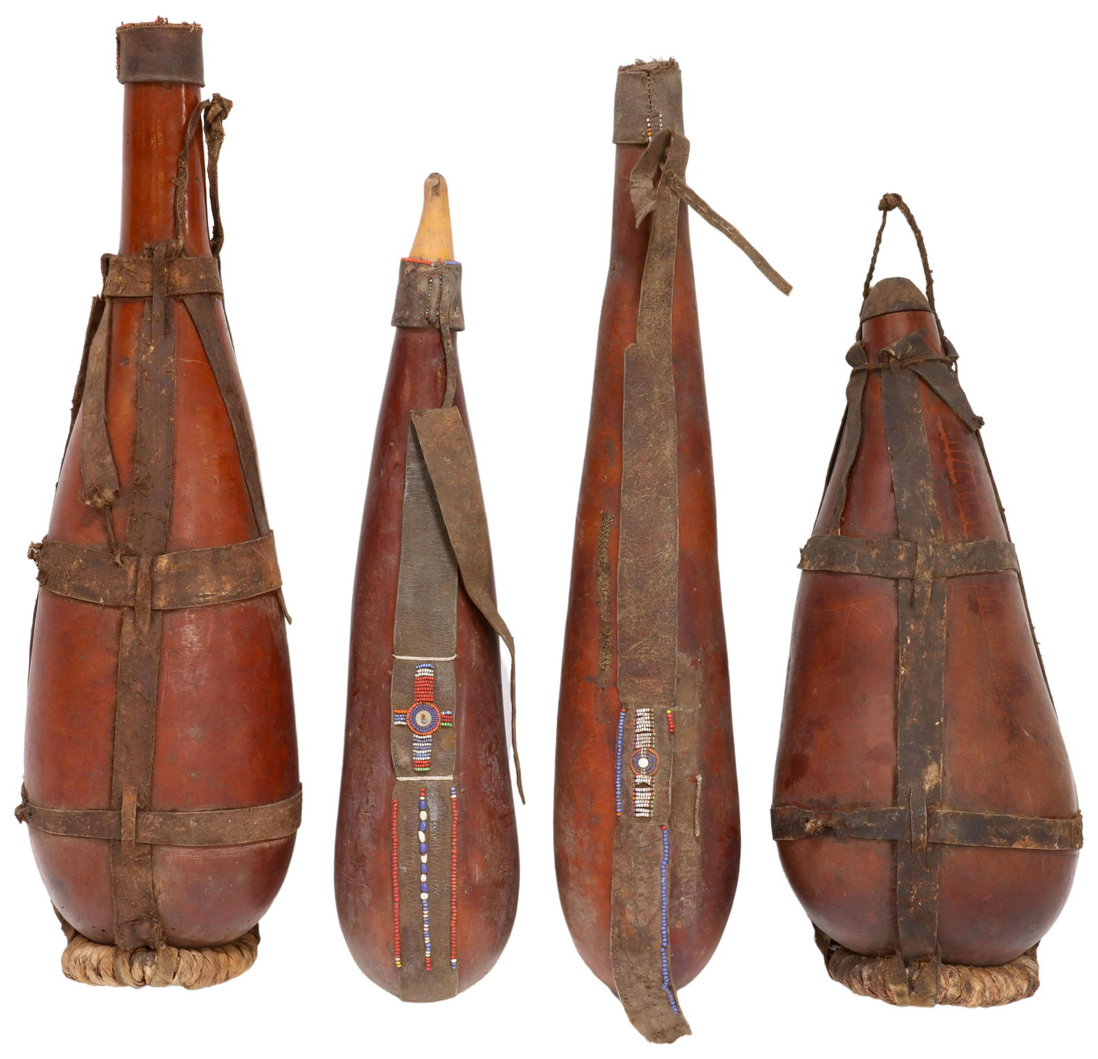 (4) AFRICAN LEATHER STRAP & BEADED GOURD JUGS: (lot of 4) African gourd jugs, all with leather straps, (three) with polychrome beaded accents, largest: approx 26.5"h, 7.75"diam, 7.25lbs total Start Price: $50.00