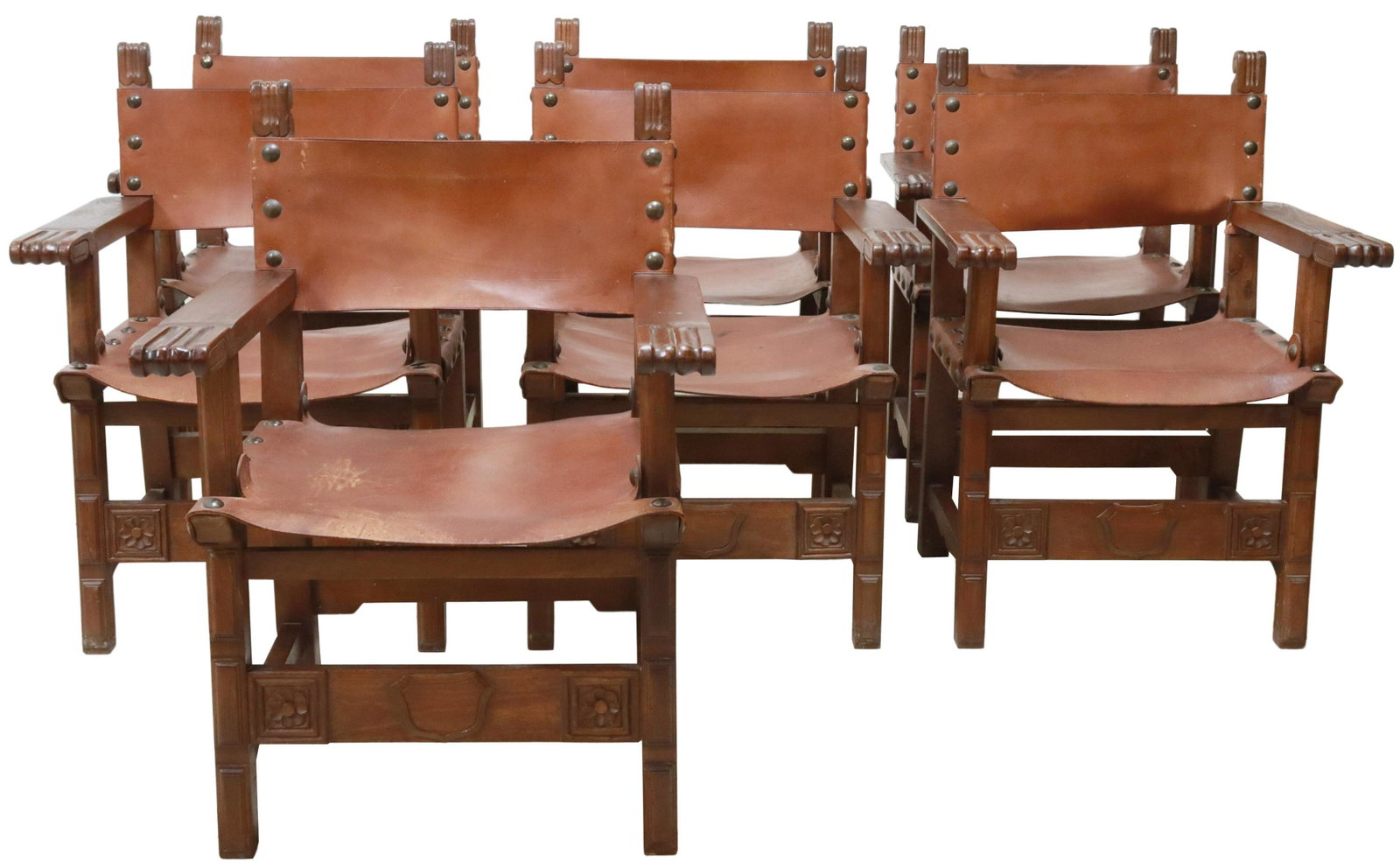 (7) SPANISH BAROQUE STYLE WALNUT LEATHER ARMCHAIRS: (lot of 7) Spanish Baroque style carved walnut armchairs, late 19th c., having leather back and sling seat held with large nail heads, scrolled handholds, rising on block legs joined by box stretcher,