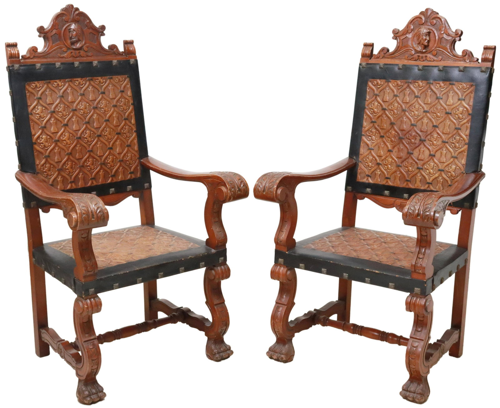 (2) SPANISH RENAISSANCE STYLE LEATHER ARMCHAIRS: (pair) Spanish Renaissance style armchairs, 20th c., carved crest with knight profile medallion, leather back and seat with embossed lions rampant and castles, acanthus scroll arms, rising on front pa