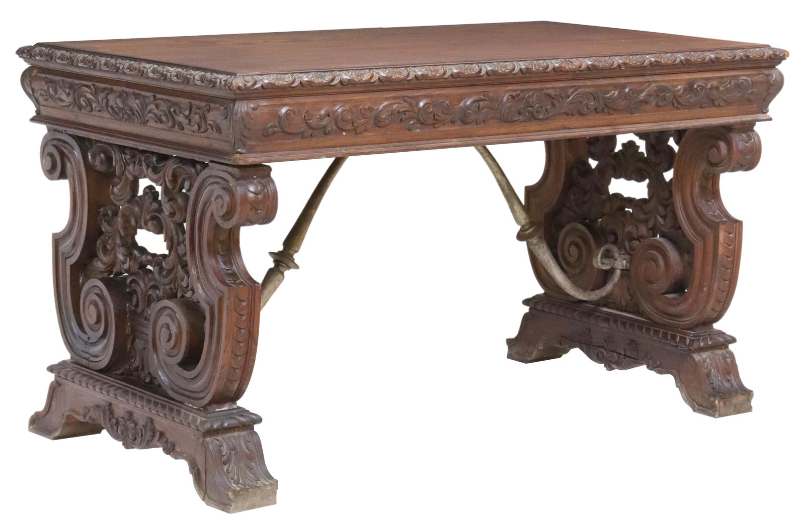 SPANISH RENAISSANCE REVIVAL OAK LIBRARY DESK: Spanish Renaissance Revival oak library desk, 19th c., having carved lunette border, fitted with three drawers, rising on pierced foliate ox yoke supports, ending on bridge feet, approx 30.75"h, 54 3/