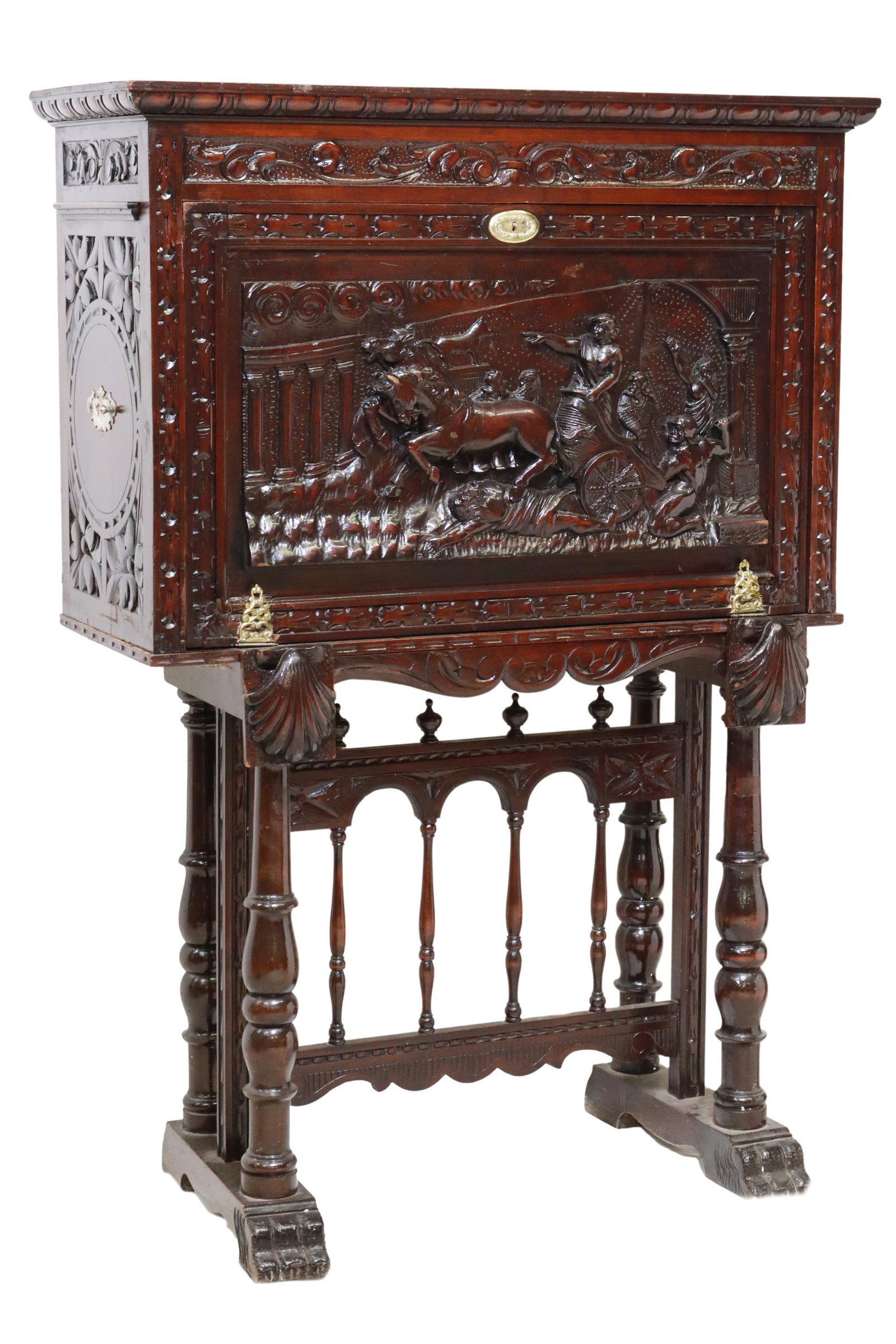 SPANISH RENAISSANCE REVIVAL VARGUENO ON STAND: Spanish Renaissance Revival bargueno/ vargueno, early 20th c., having egg and dart border, fall-front with carved chariot scene, opening to interior gallery, over shell pull-out supports, rising on st