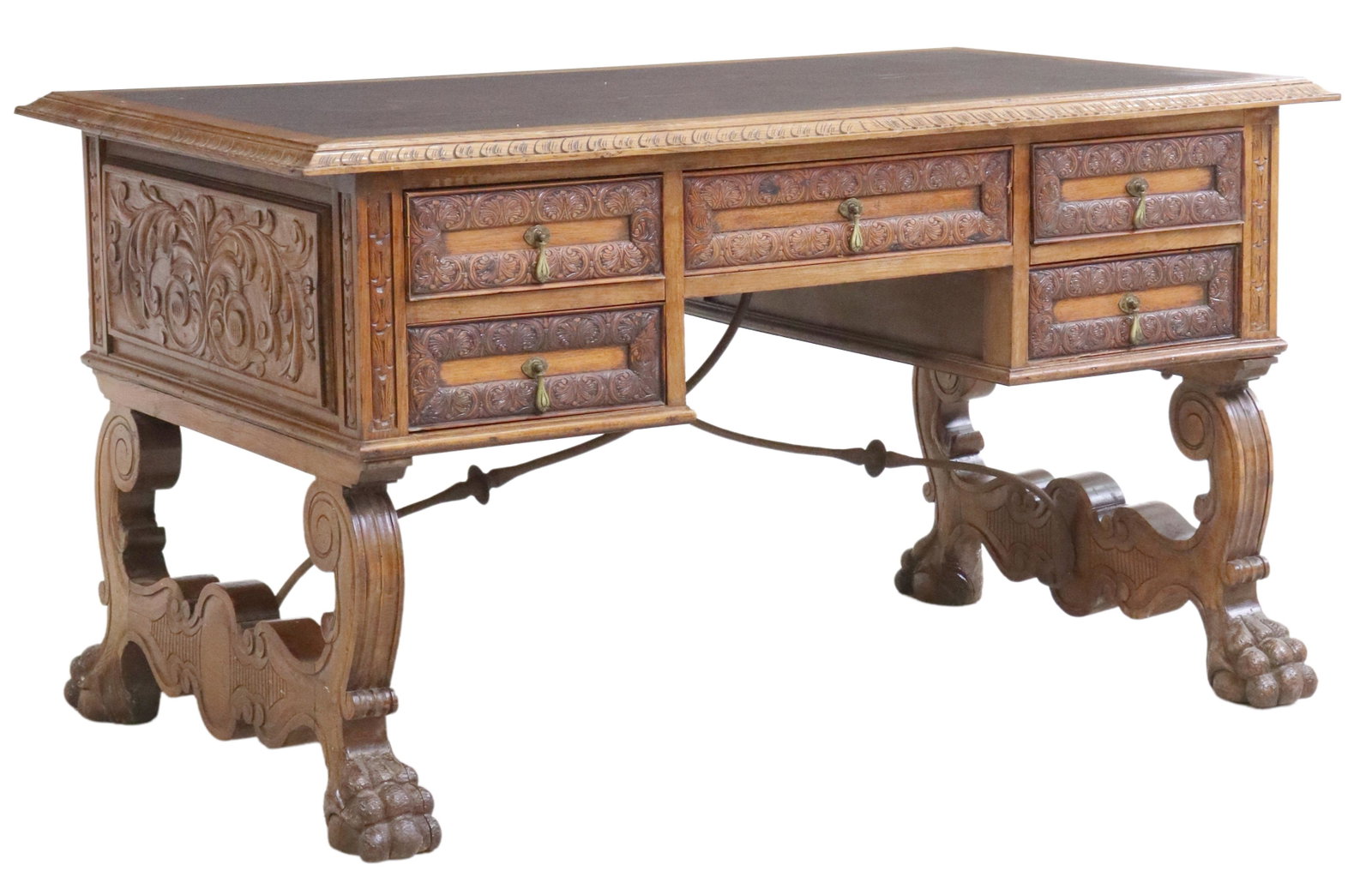 SPANISH RENAISSANCE REVIVAL OAK LIBRARY DESK: Spanish Renaissance Revival oak library desk, early 20th c., contrasting top with carved border, over five drawers, faced with lunettes, rising on ox yoke supports, joined with iron cross stretcher, e