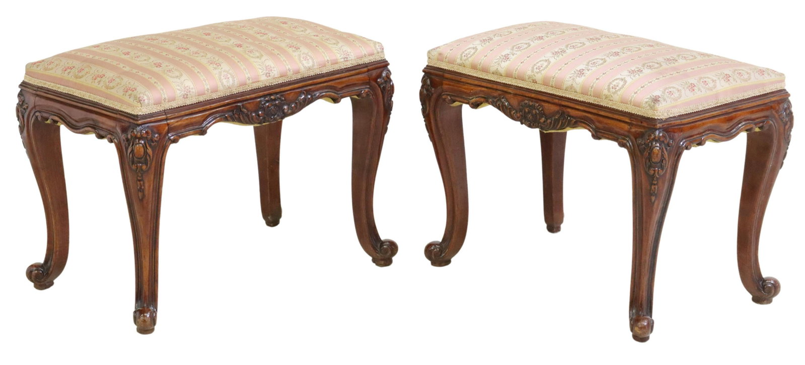 (2) LOUIS XV STYLE UPHOLSTERED MAHOGANY FOOTSTOOLS: (pair) Louis XV style mahogany footstools, 20th c., patterned upholstery, over carved foliate apron, rising on cabriole legs, ending on whorl feet, approx 17.25"h, 23.25"w, 14.5"d Start Price: $200.00