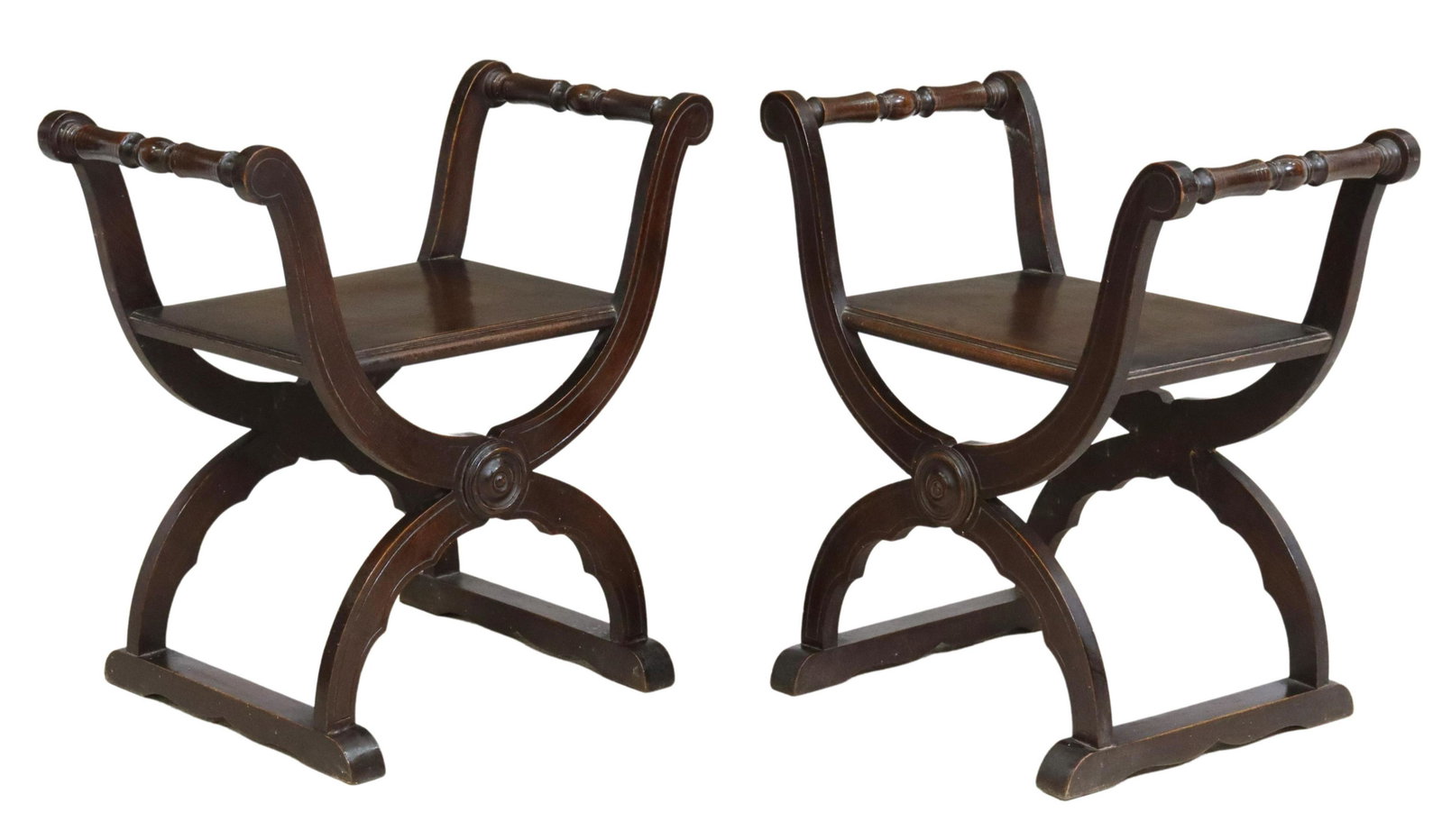 (2) SPANISH RENAISSANCE REVIVAL CURULE STOOLS: (pair) Spanish Renaissance Revival stools, early /20th c., having scrolled turned arms, rising on curule base, with carved circular motif, ending on bridge feet, (one) with restoration to leg, approx 