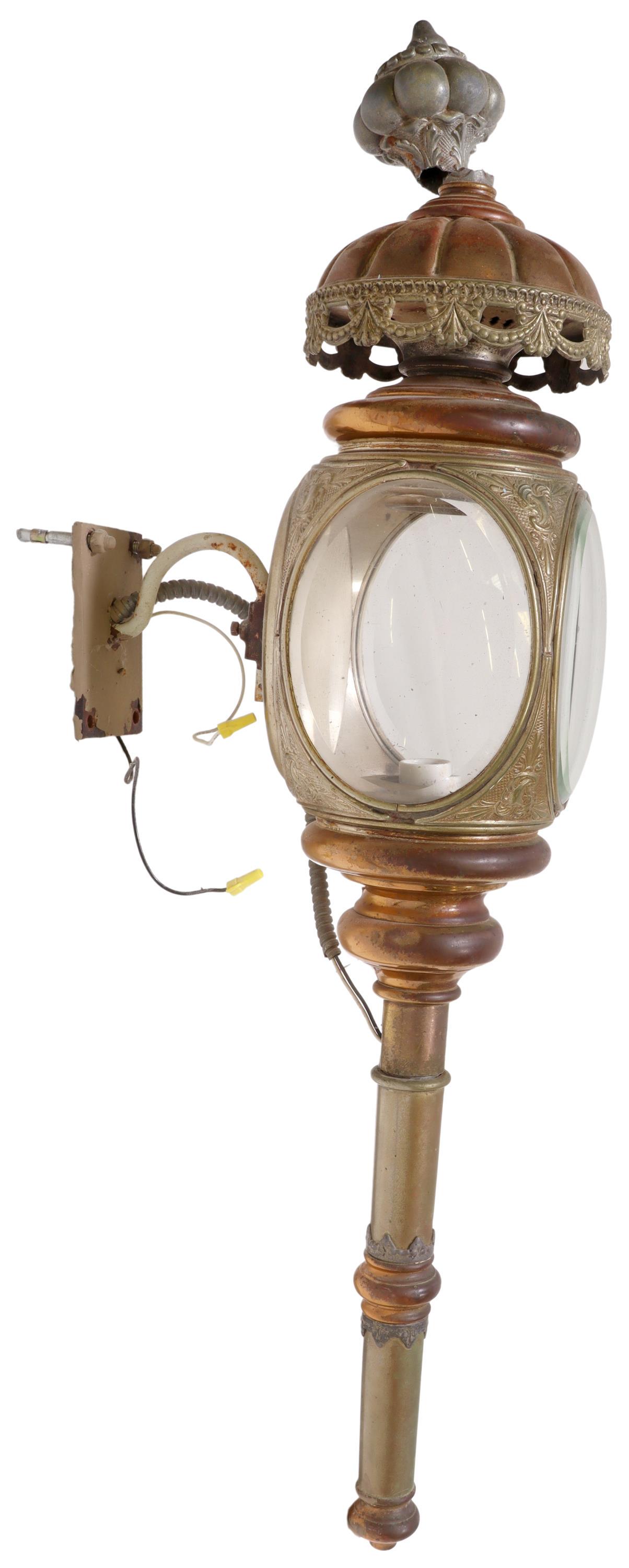 BRASS & COPPER PLATED COACH LANTERN WALL SCONCE: Brass and copper plated coach lantern, now electrified with later wall-mounting bracket, three beveled glass windows, single interior light, break to metal at finial, approx 43.5"l **Provenance: Accor