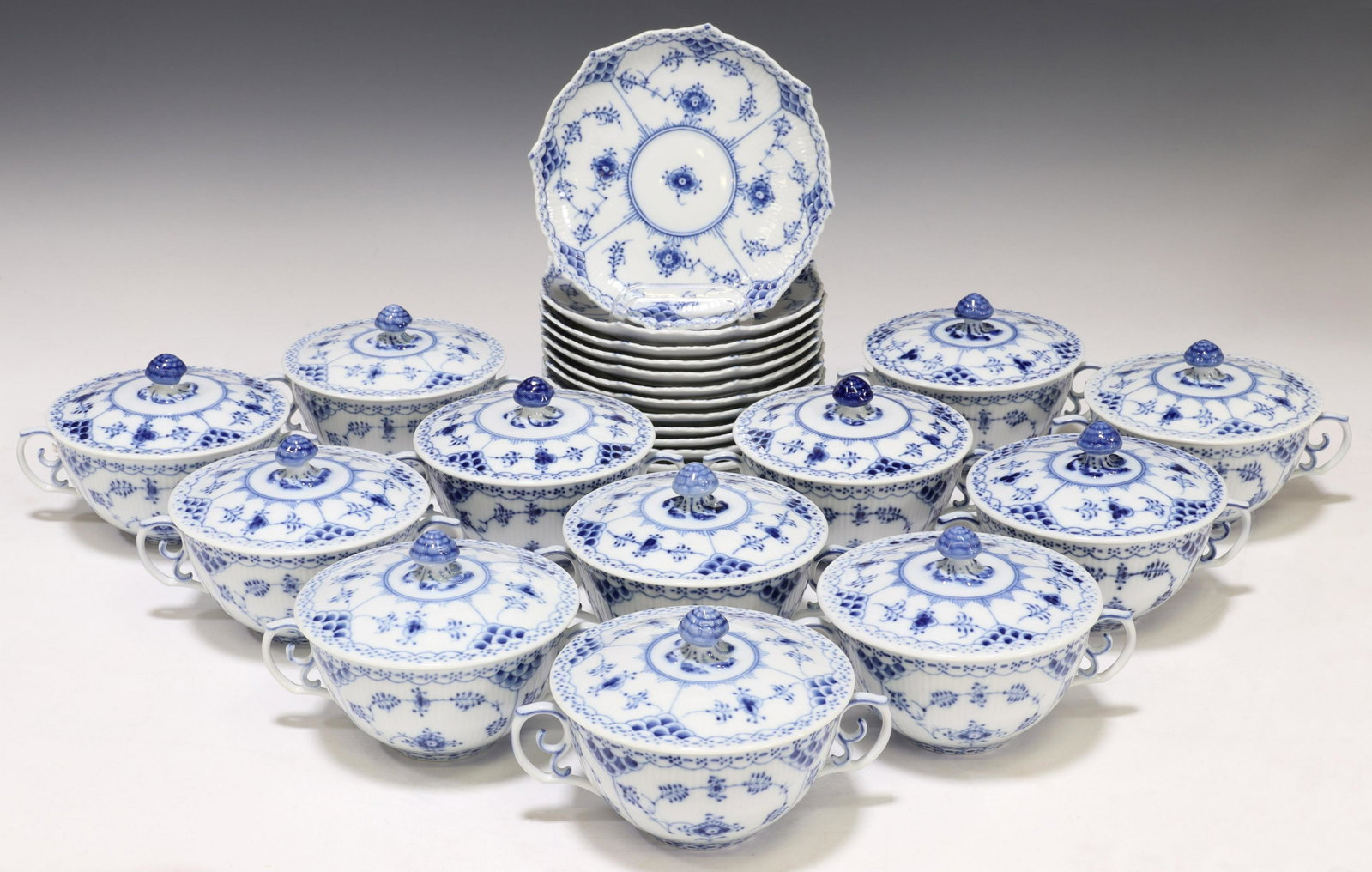 (36) ROYAL COPENHAGEN BLUE FLUTED FULL LACE SET: (lot) Royal Copenhagen porcelain cream soup bowls and saucers, service for twelve, in the "Blue Fluted Full Lace" pattern, including: (12) cream soup bowls, approx 2.5"h, 6.25"w, 4.5"diam; (12) lids, 