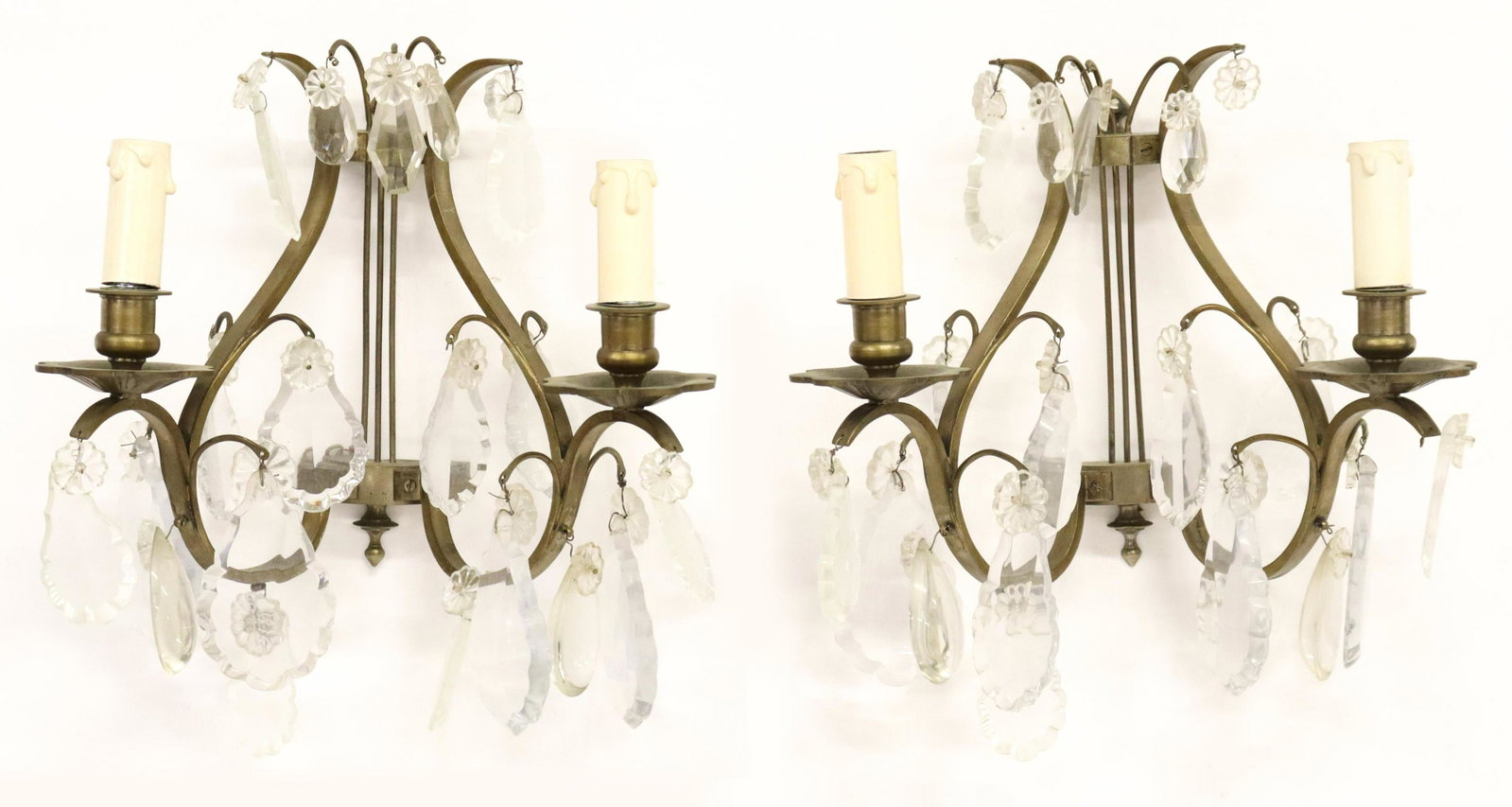(2) ITALIAN BRONZE LYRE-FORM CRYSTAL WALL SCONCES: (pair) Italian two-light bronze wall sconces, 20th c., backplate in the form of a lyre, issuing two floral bobeches, hung with pendalogues and crystals, in need of wiring, lacking one pendalogue, appr