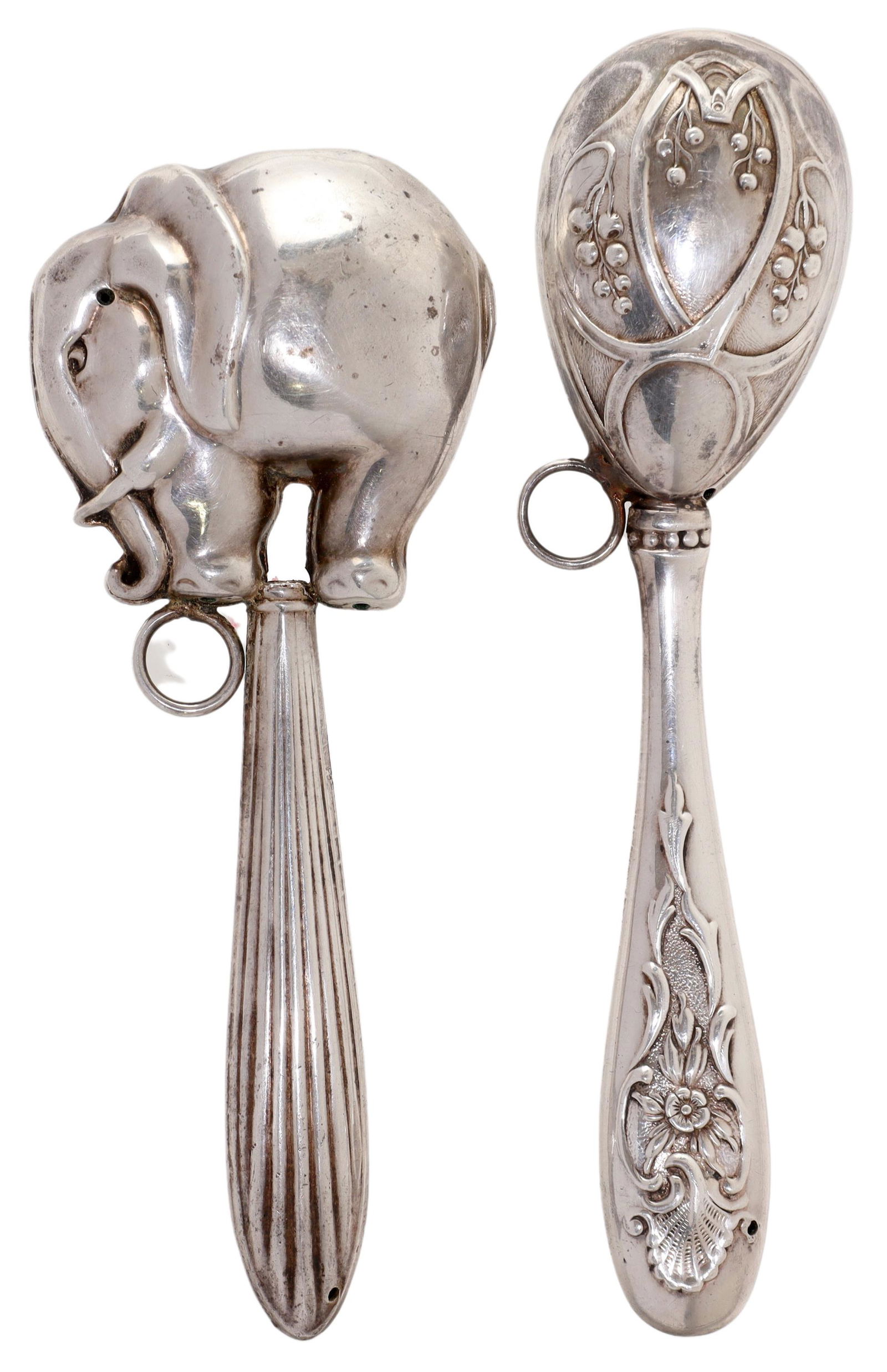 (2) SILVER ELEPHANT & FLORAL BABY RATTLES: (lot of 2) Silver (content unknown) baby rattles, including: (1) modeled as an elephant, approx 4 5/8"l, (1) egg-shaped with repousse floral decoration, approx 5"l; some denting, 60 grams total (inclu