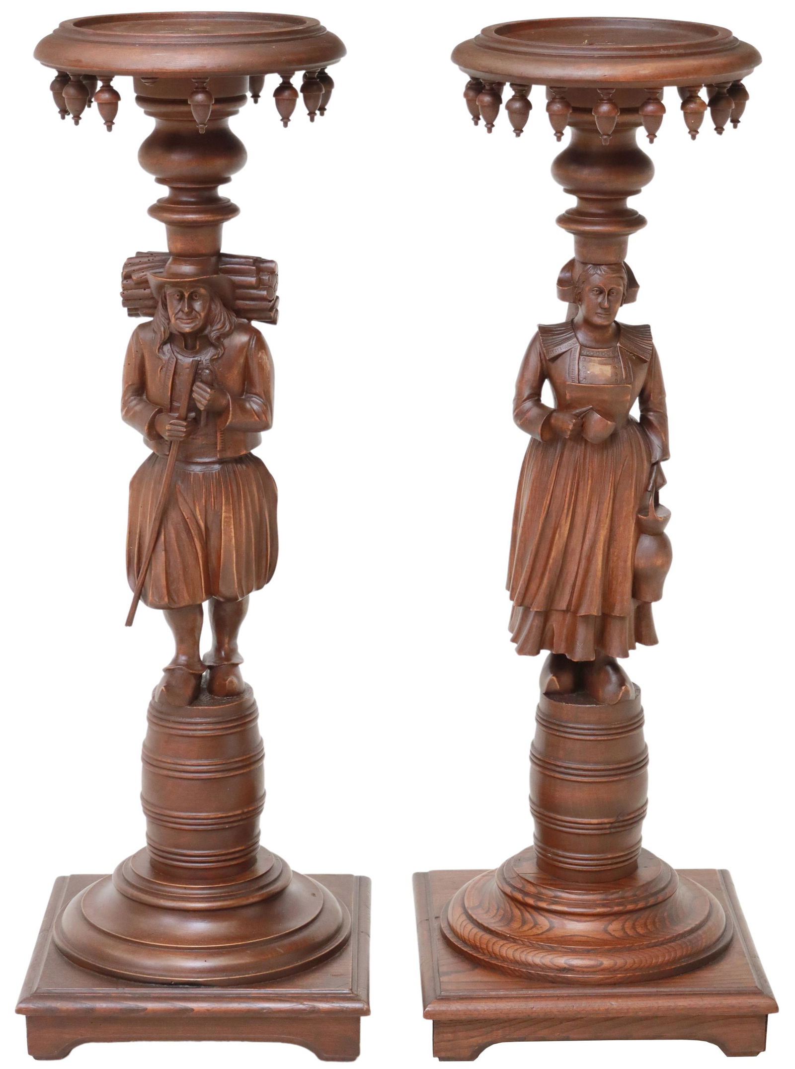 (2) FRENCH BRETON FIGURAL CARVED STANDS/ PEDESTALS: (lot of 2) French carved pedestals/ plant stands, Brittany, late 19th c., dish top, framed by drop finials, full-body figural supports, (one) modeled as a woman carrying a bucket, (one) as a man carry