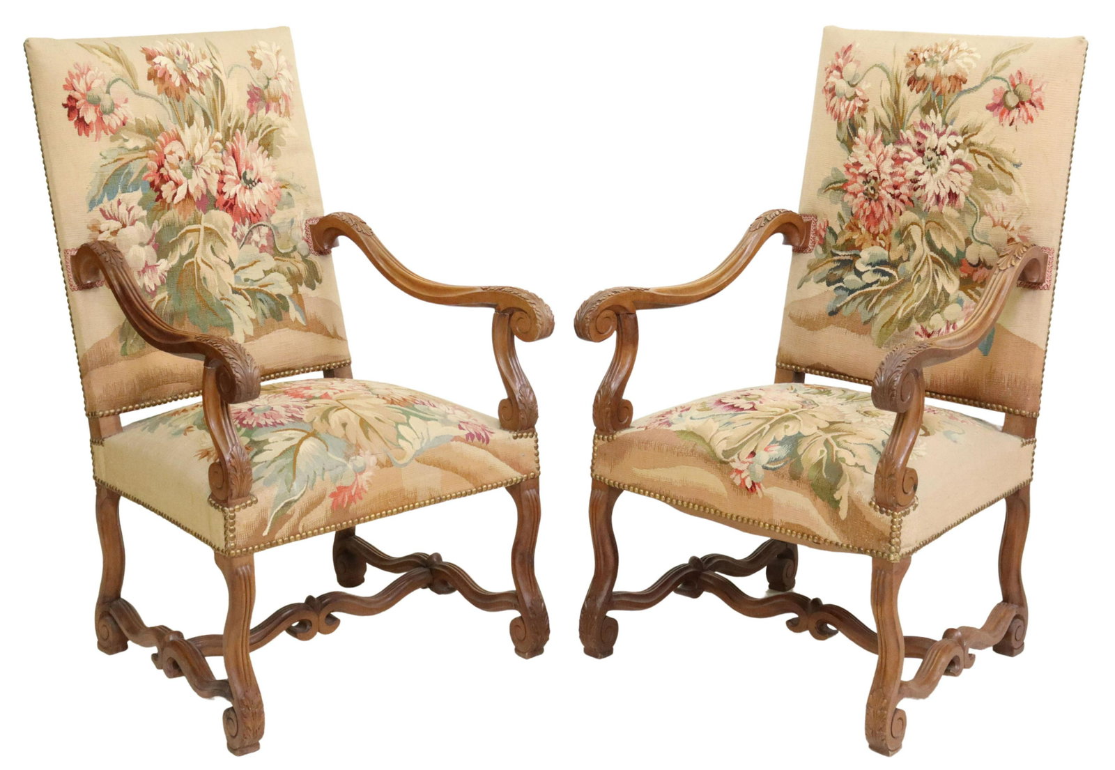 (2) FRENCH LOUIS XIV STYLE TAPESTRY FAUTEUILS: (pair) French Louis XIV style walnut armchairs, early 20th c., back and seat in floral tapestry upholstery, with nailhead trim, foliated scroll handholds, rising on volute legs, joined with cross stre