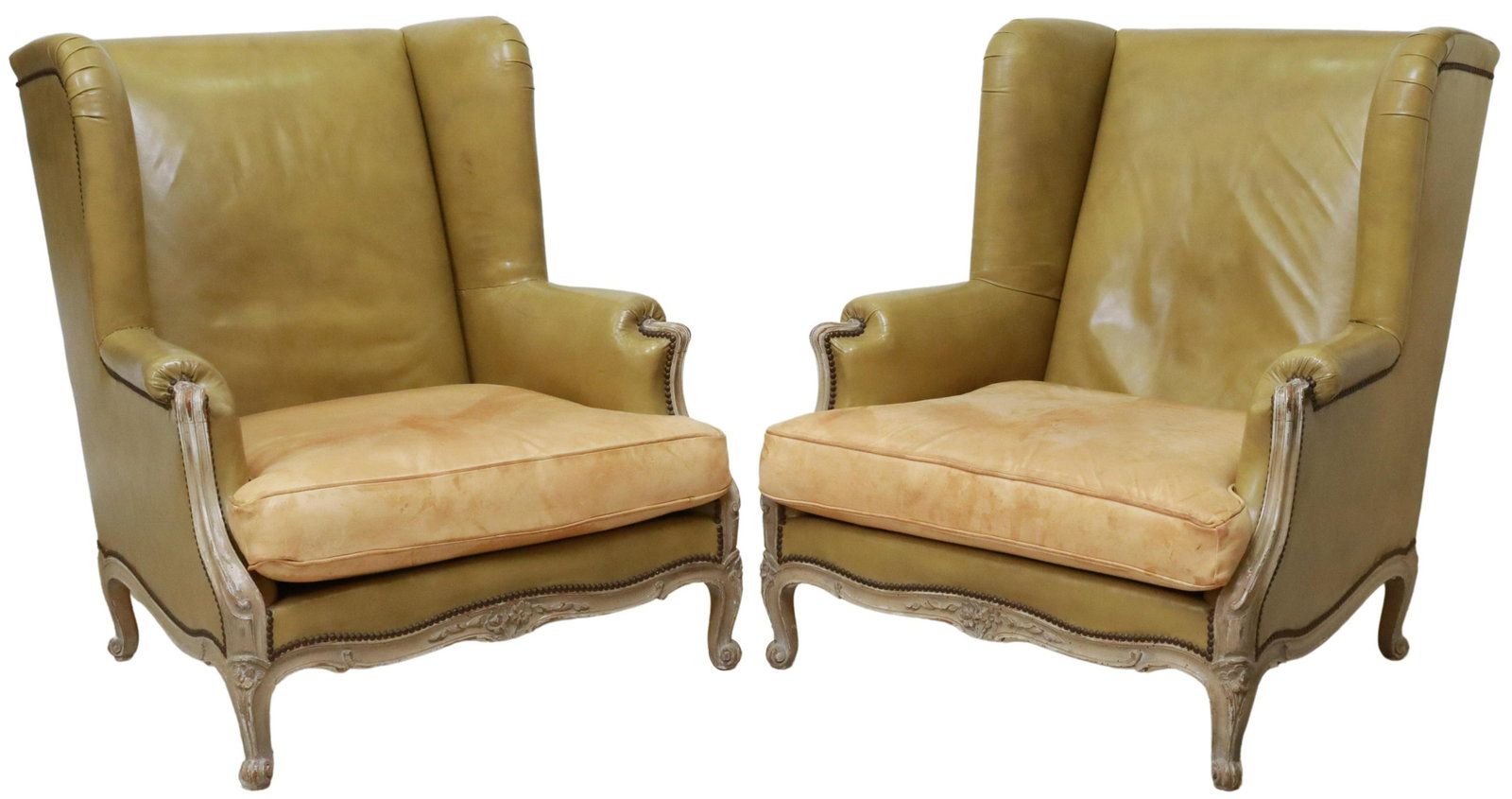 (2) LOUIS XV STYLE LEATHER WINGBACK ARMCHAIRS: (pair) Louis XV style wingback armchairs, 20th c., in olive leather upholstery, with nailhead trim, painted wood frame, removable seat cushion, rising on cabriole legs, ending in whorl feet, discolora