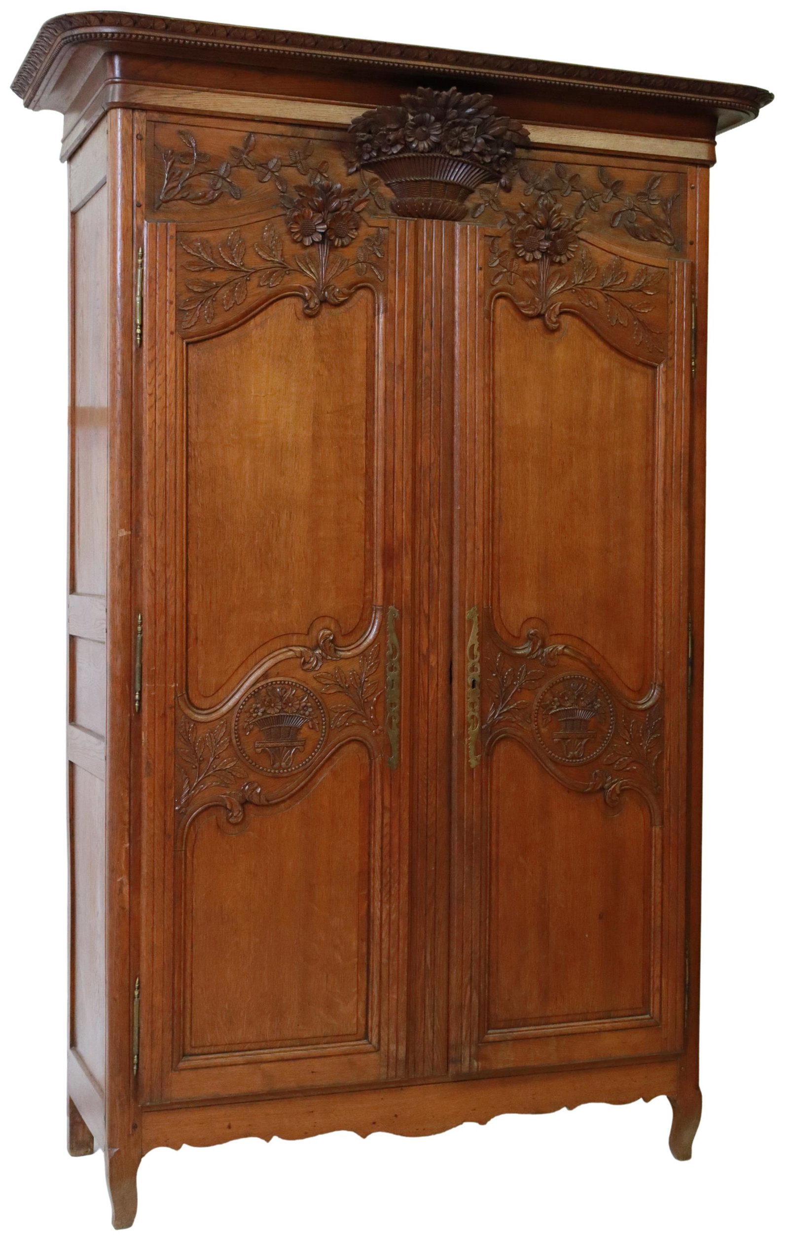FRENCH PROVINCIAL CARVED OAK WEDDING ARMOIRE: French Provincial oak wedding armoire, late 19th c., having molded cornice, frieze with basket of flowers carved in relief, two paneled doors with scrolled foliates and floral motifs, open interior, r