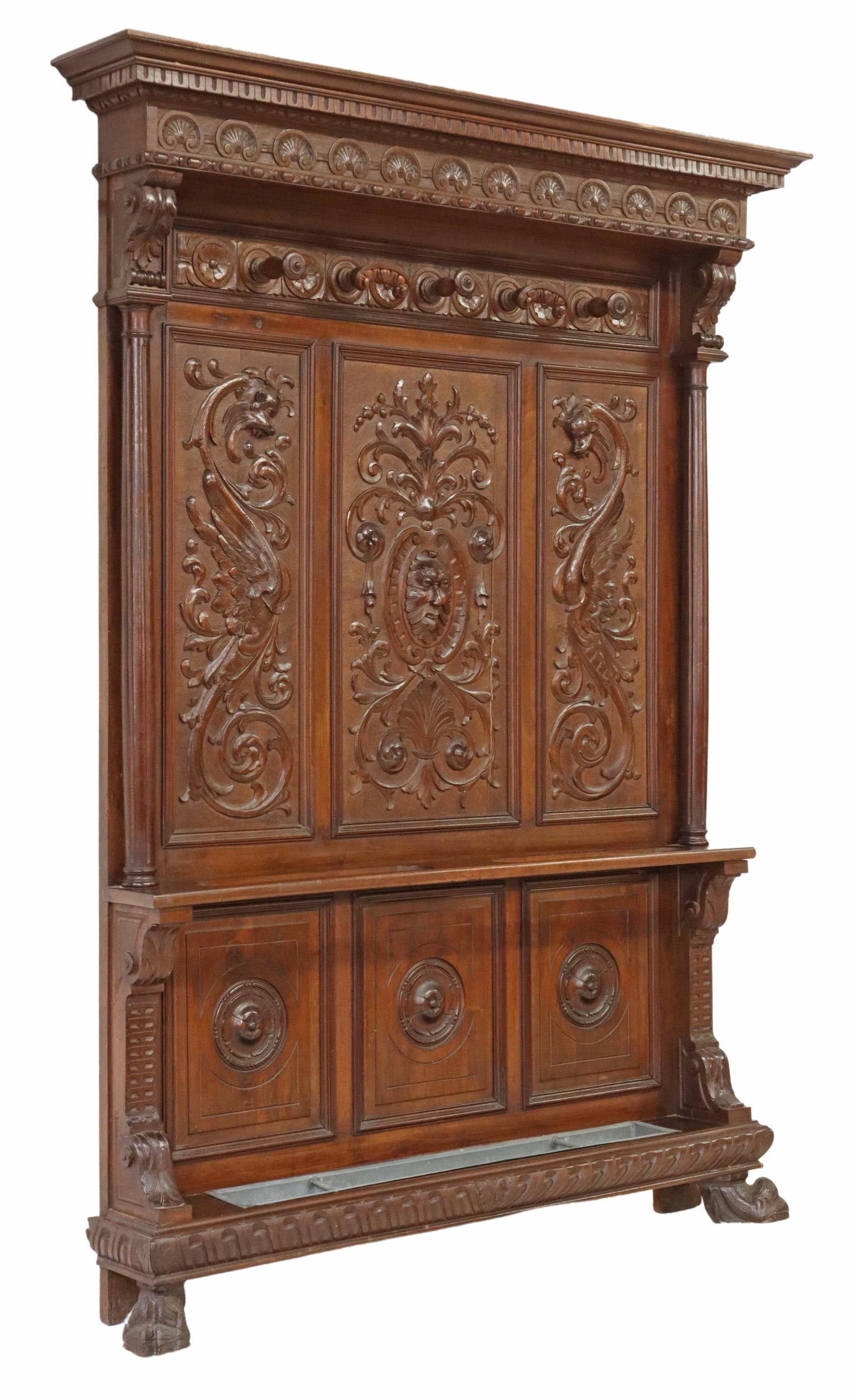 ITALIAN RENAISSANCE REVIVAL CARVED HALL TREE: Italian Renaissance Revival carved walnut hall tree, 19th c., molded cornice, over lunette border, five protruding hooks, back panels carved with scrolling foliates and dragons, centering protruding g