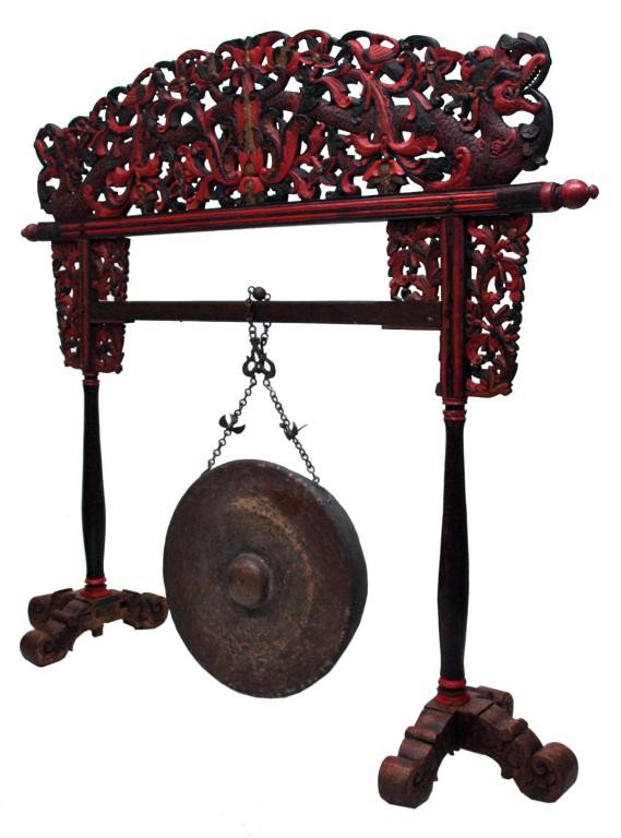 BALINESE BRONZE GONG, LARGE CARVED DRAGON STAND: Balinese bronze gong on elaborate polychrome gilt accented wood stand carved with painted dragons and birds, some missing wood, loss, restoration, gong: 27.25"d, stand: 75"h, 82"w, 23.25"d Start Price