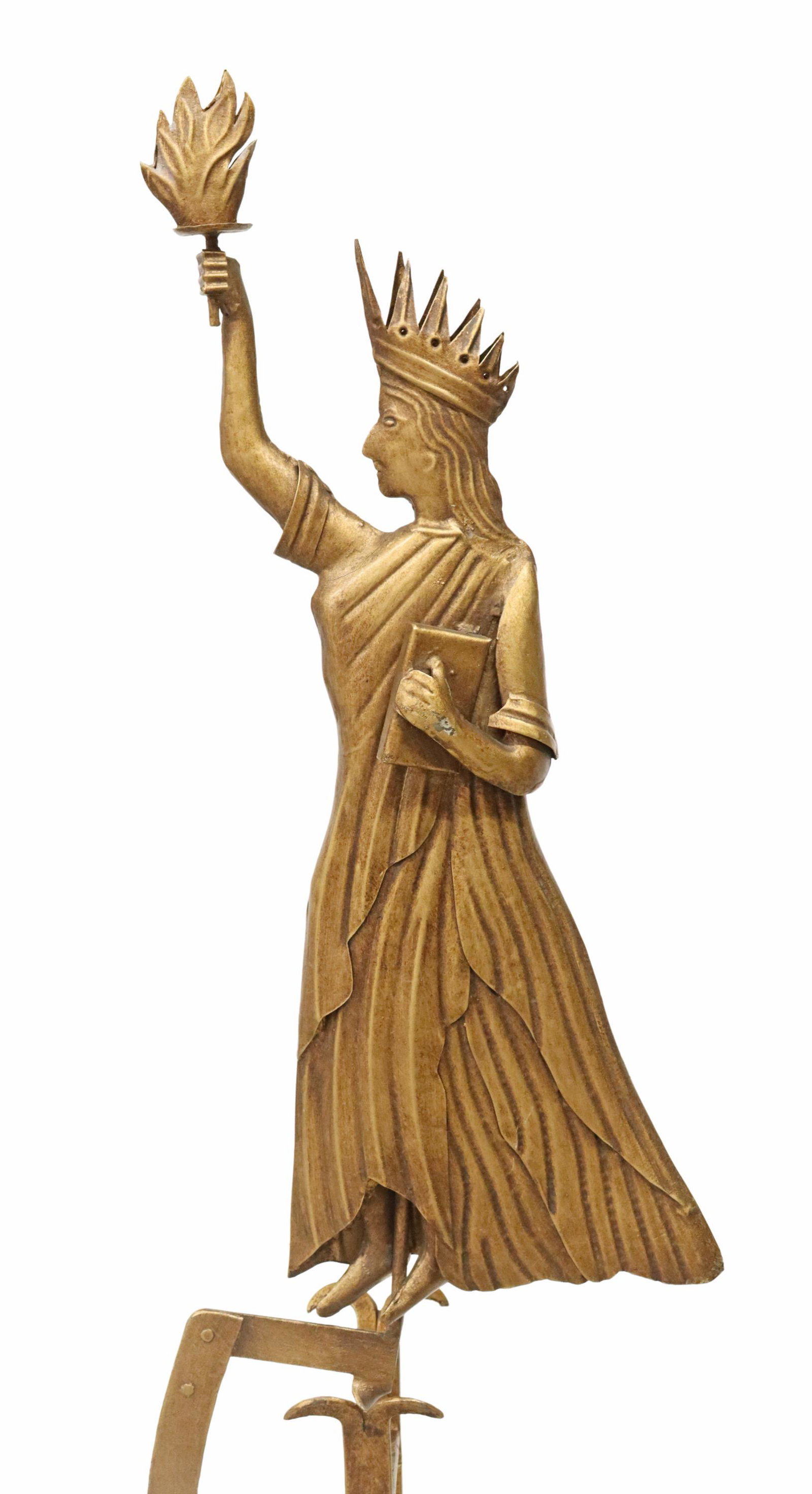 KINETIC BALANCING FIGURE, STATUE OF LIBERTY: Gilt metal kinetic balancing figure, Statue of Liberty, late 20th c., flat form figure in profile, over pendulum weight, rising on stand ending on tripartite base, approx 60"h, 13"sq Start Price: $150
