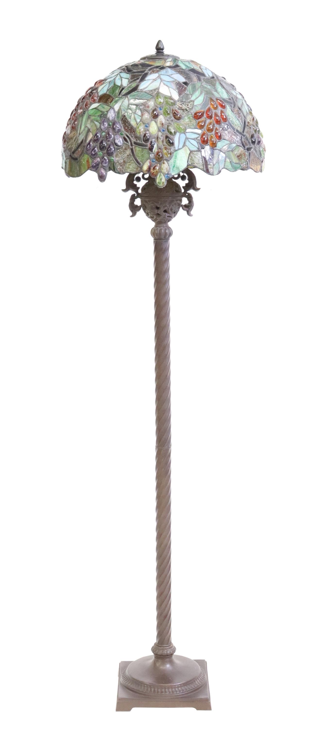 TIFFANY STYLE STAINED & LEADED GLASS FLOOR LAMP: Tiffany style stained and leaded glass floor lamp, domed shade with leafy grape clusters, over pierced foliate urn-form accent, rising on twisted standard, ending on square base, with bridge feet, app