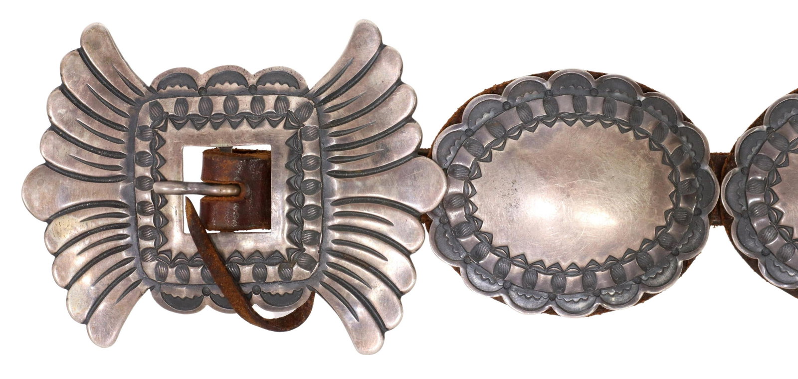 SOUTHWEST DA HARRIS SANTA FE STERLING CONCHO BELT: Southwest sterling silver concho belt, signed D.A. Harris (Dale Harris, Santa Fe), shaped buckle and nine oval conchos, with stampwork, on a worn slim leather belt, belt: approx 25.75"l (buckle catch 
