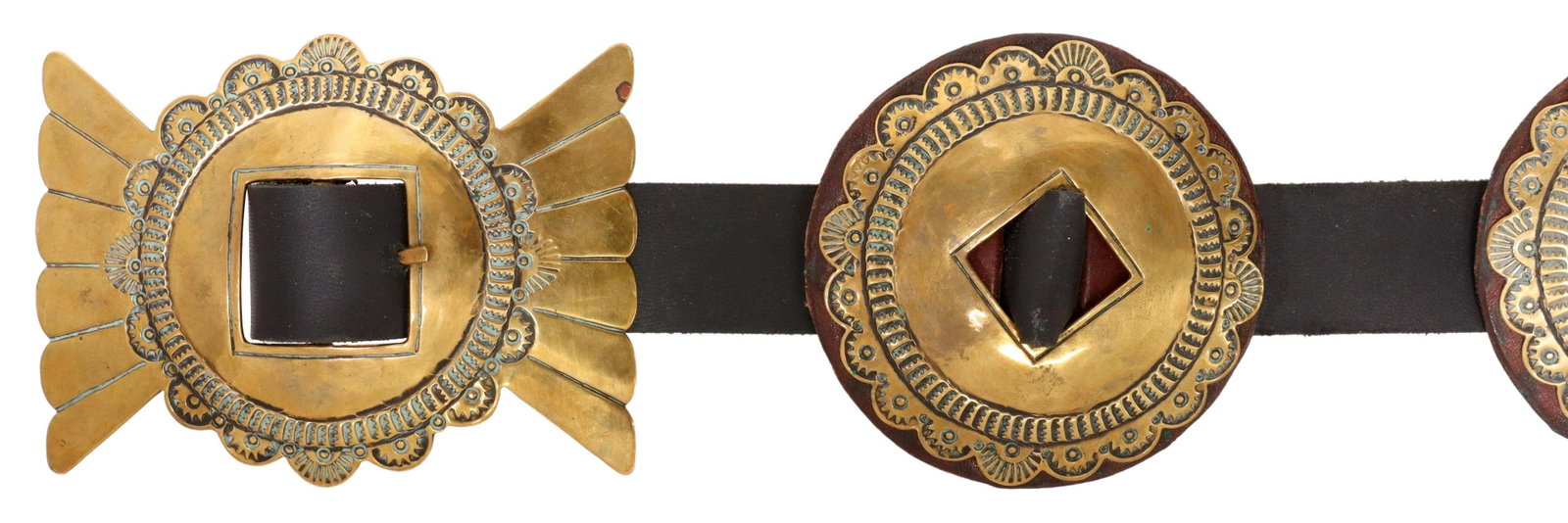 NAVAJO LUCKY EARTHWALKER STAMPWORK CONCHO BELT: Native American concho belt, Lucky Earth Walker (Navajo), dated 1987, possibly brass, bow form buckle and eight round leather backed conchos, all with stampwork, on a black leather belt with rough end