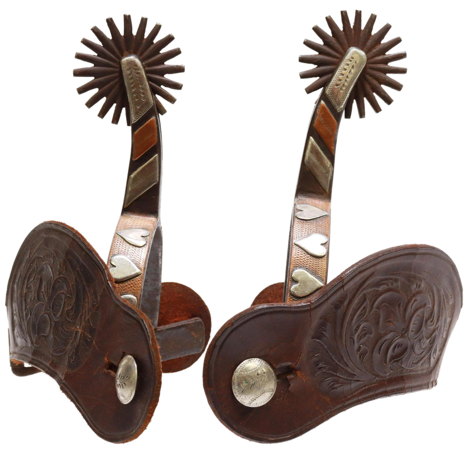 KELLY BROS SILVER MOUNTED HEART PATTERN SPURS: (pair) Western cowboy spurs, Kelly Brothers, outside heelband mounted with copper strips and three silver hearts, 1 7/8" rowels, twenty points, worn tooled leather straps with silver button, marked Ke